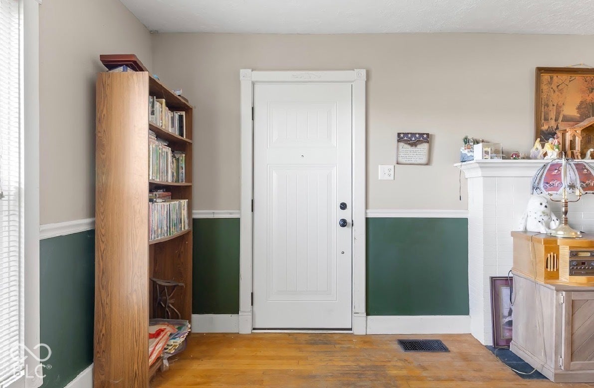 Wood-finish flooring, white paneled door, and two-tone wall treatment