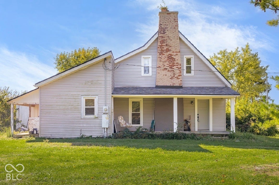 Siding exterior with brick chimney accent, covered front porch, and pitched rooflines