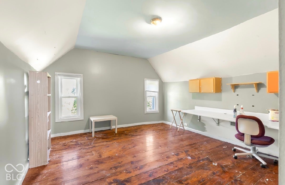 Wood-finish flooring, multiple windows, built-in wall shelving, and built-in cabinetry