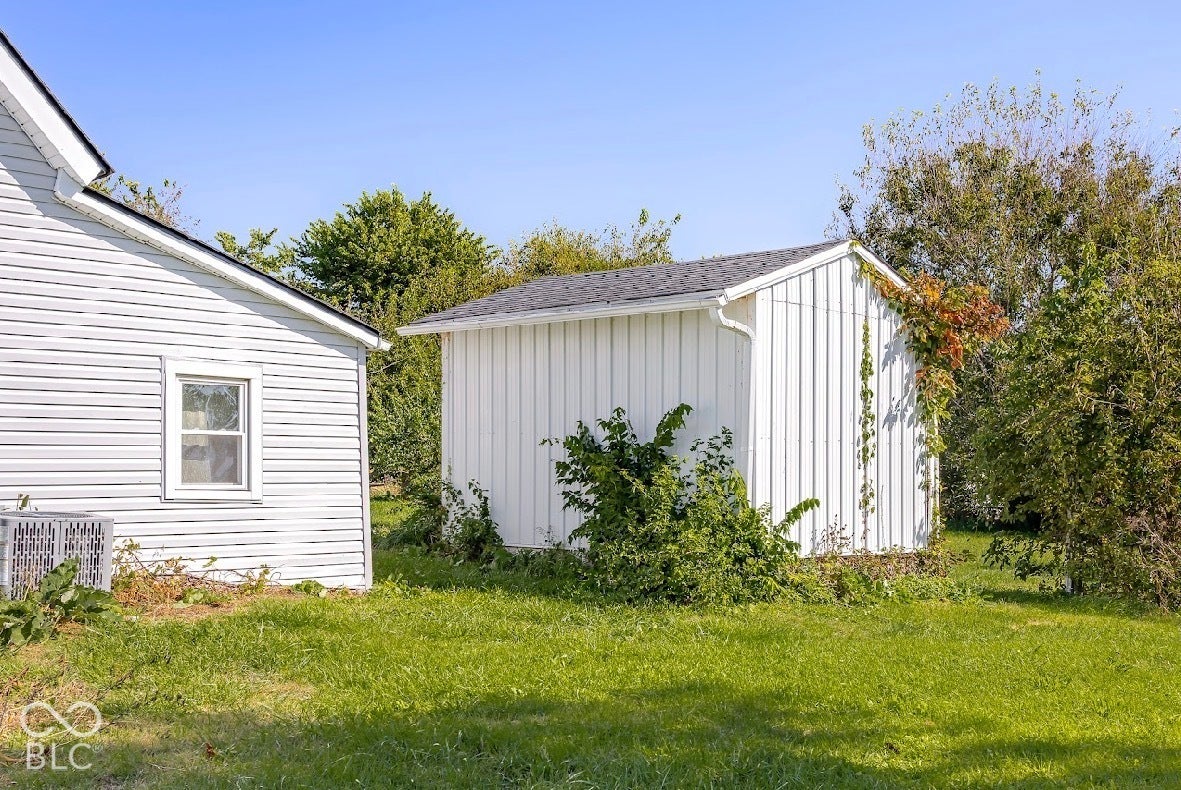 White vinyl siding on the primary structure with a single window