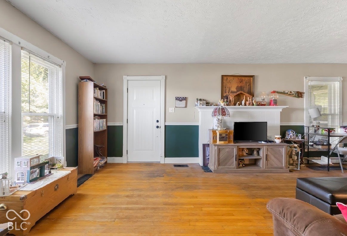 Hardwood flooring, painted interior door, picture windows, two-tone wall treatment, fireplace mantel