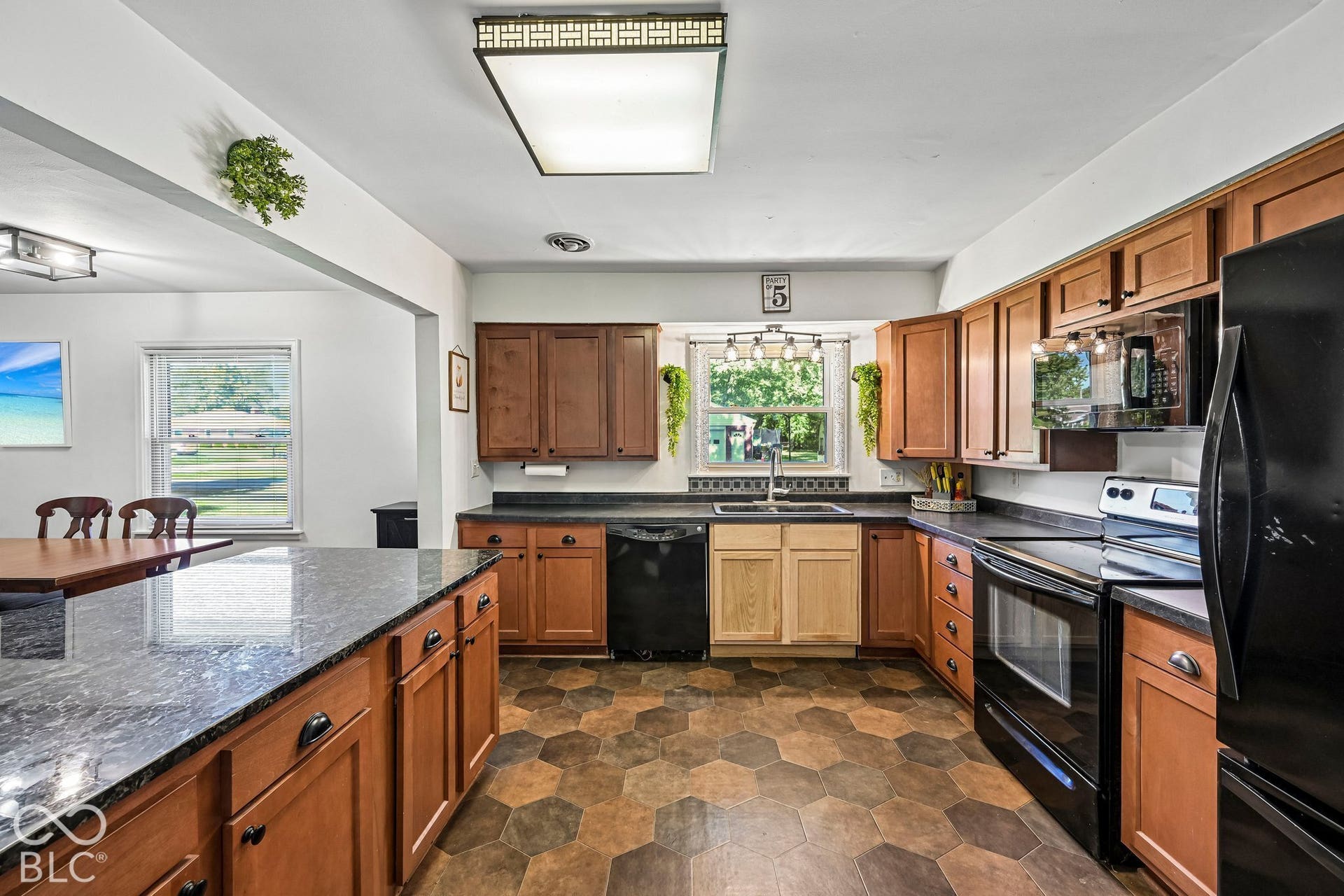 Kitchen with wood-finish cabinetry, dark countertops, and hexagonal tile flooring