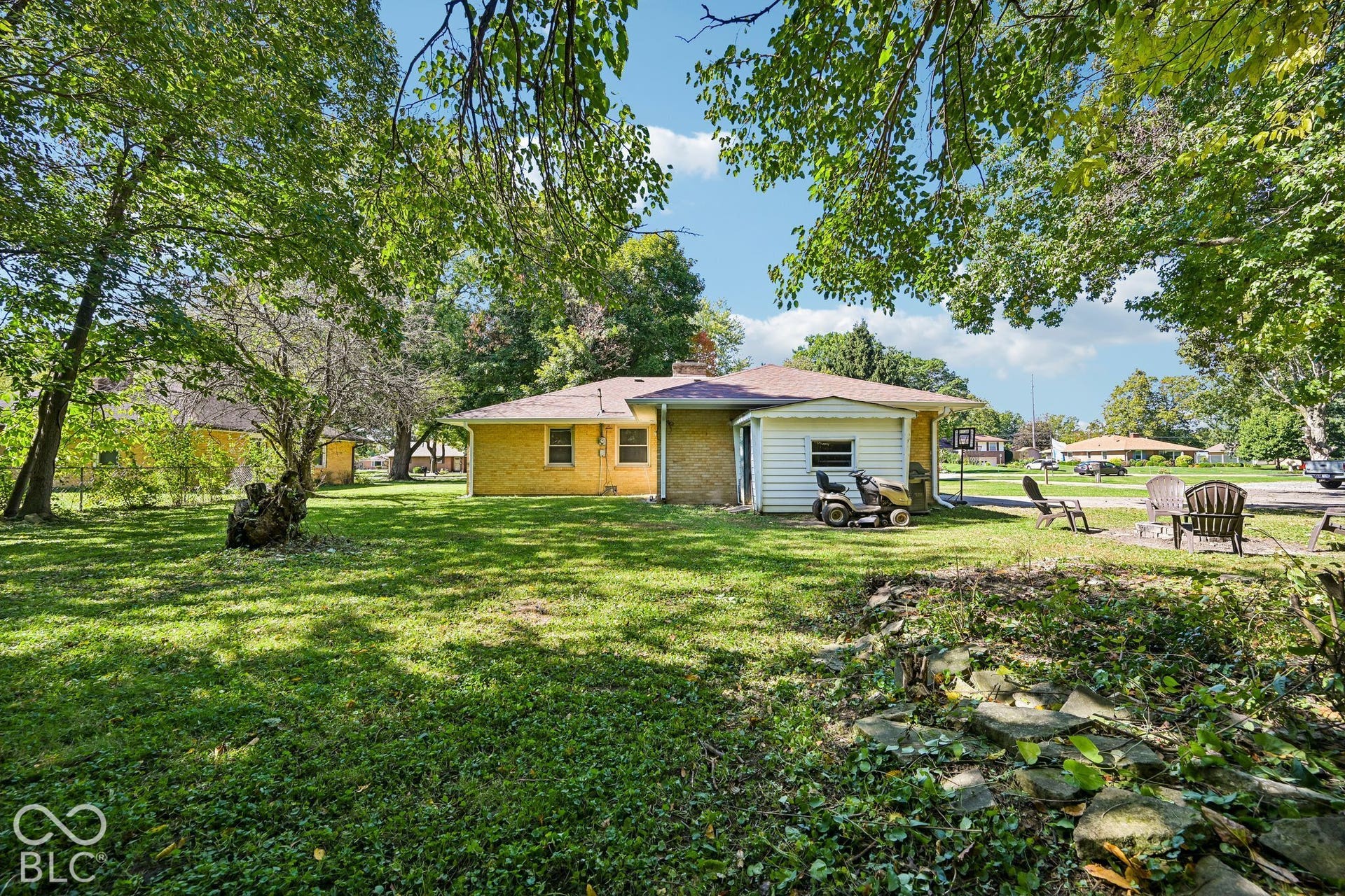 Expansive green lawn with mature trees and a brick exterior