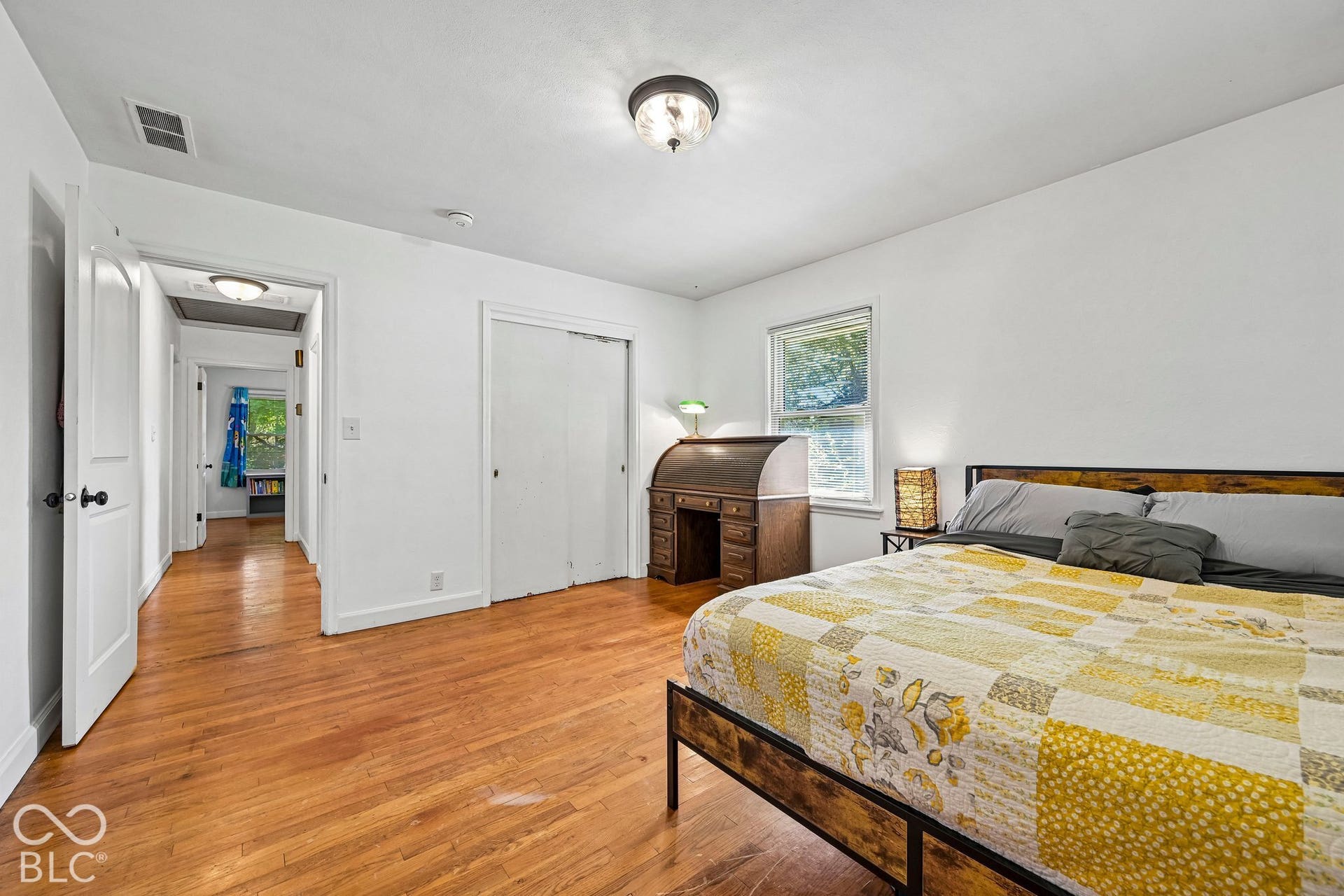 Wood-finish flooring throughout, white walls, and a recessed window