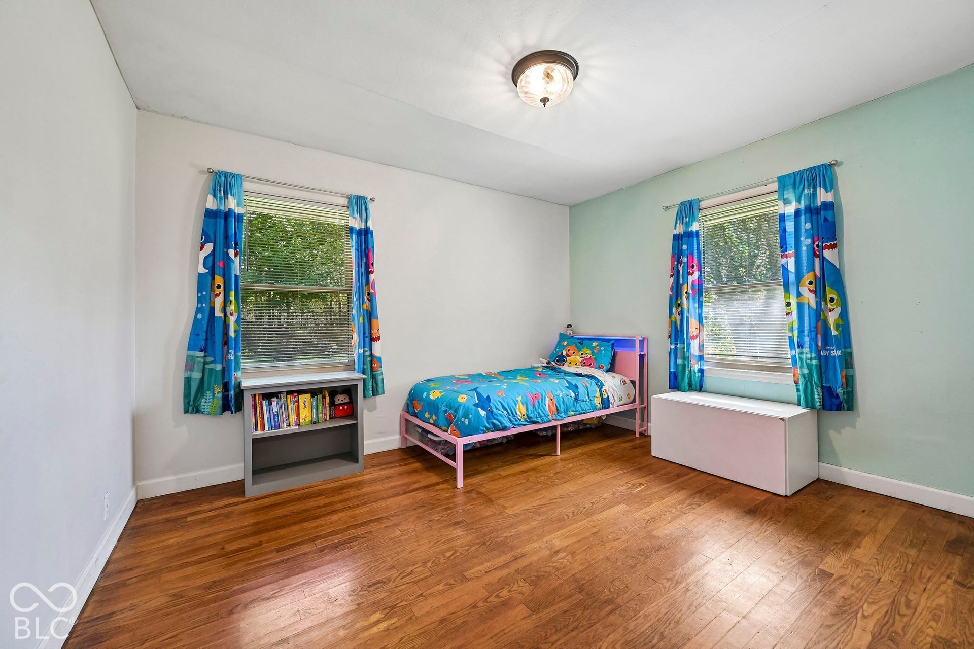 Hardwood-style flooring in a room with a semi-flush mount ceiling light