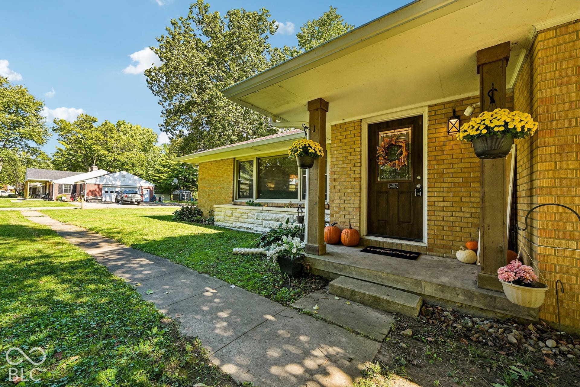 Brick exterior with a covered entry, wood-finish columns, and exterior lighting