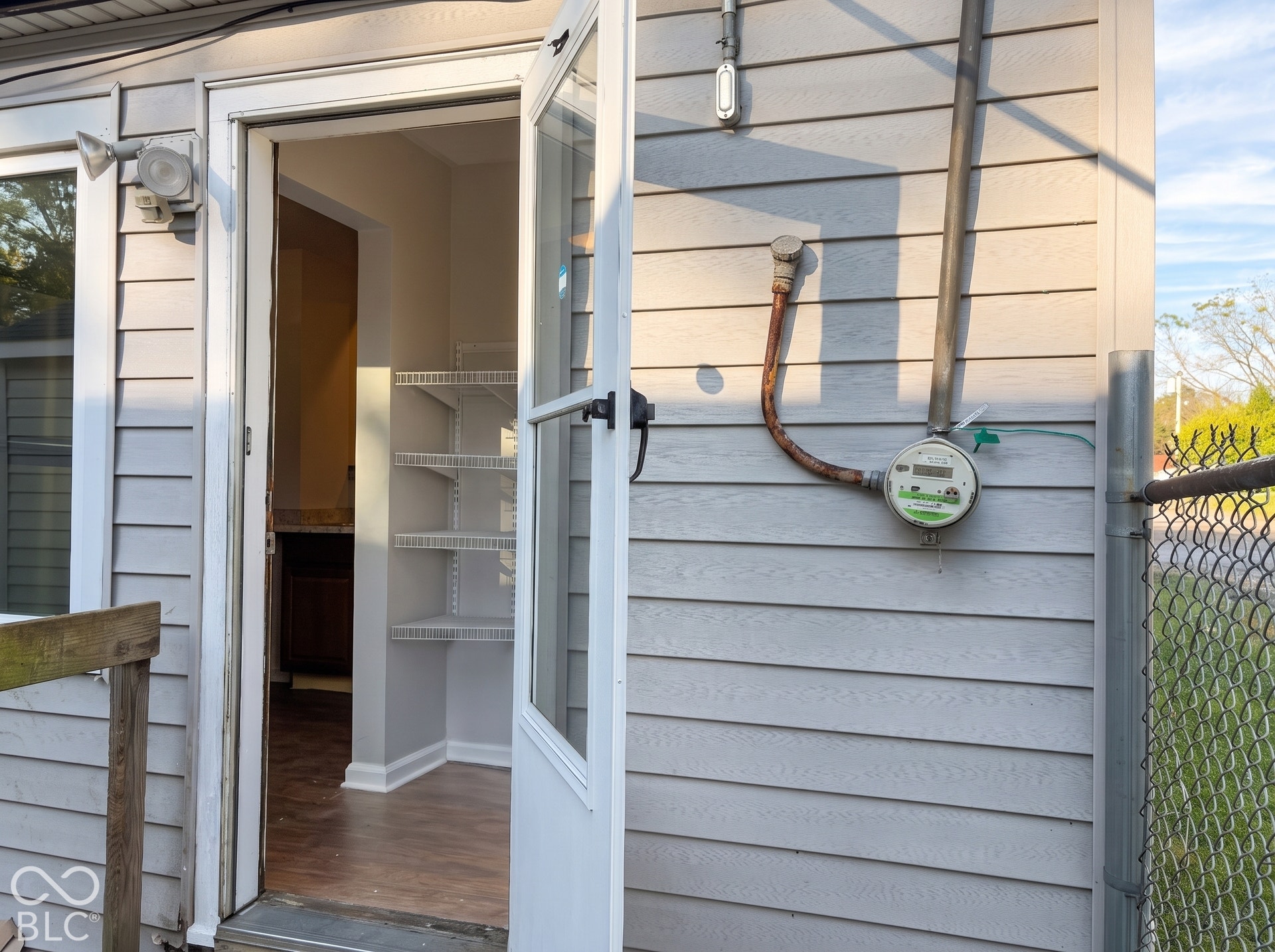 Exterior featuring horizontal siding, outdoor lighting, and an entry door