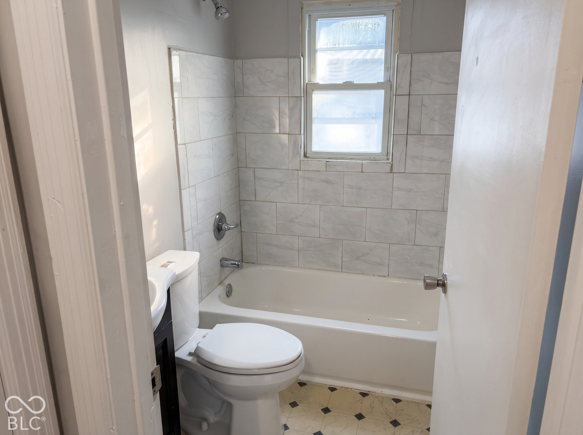 White ceramic subway tile surround with a built-in bathtub and shower fixture