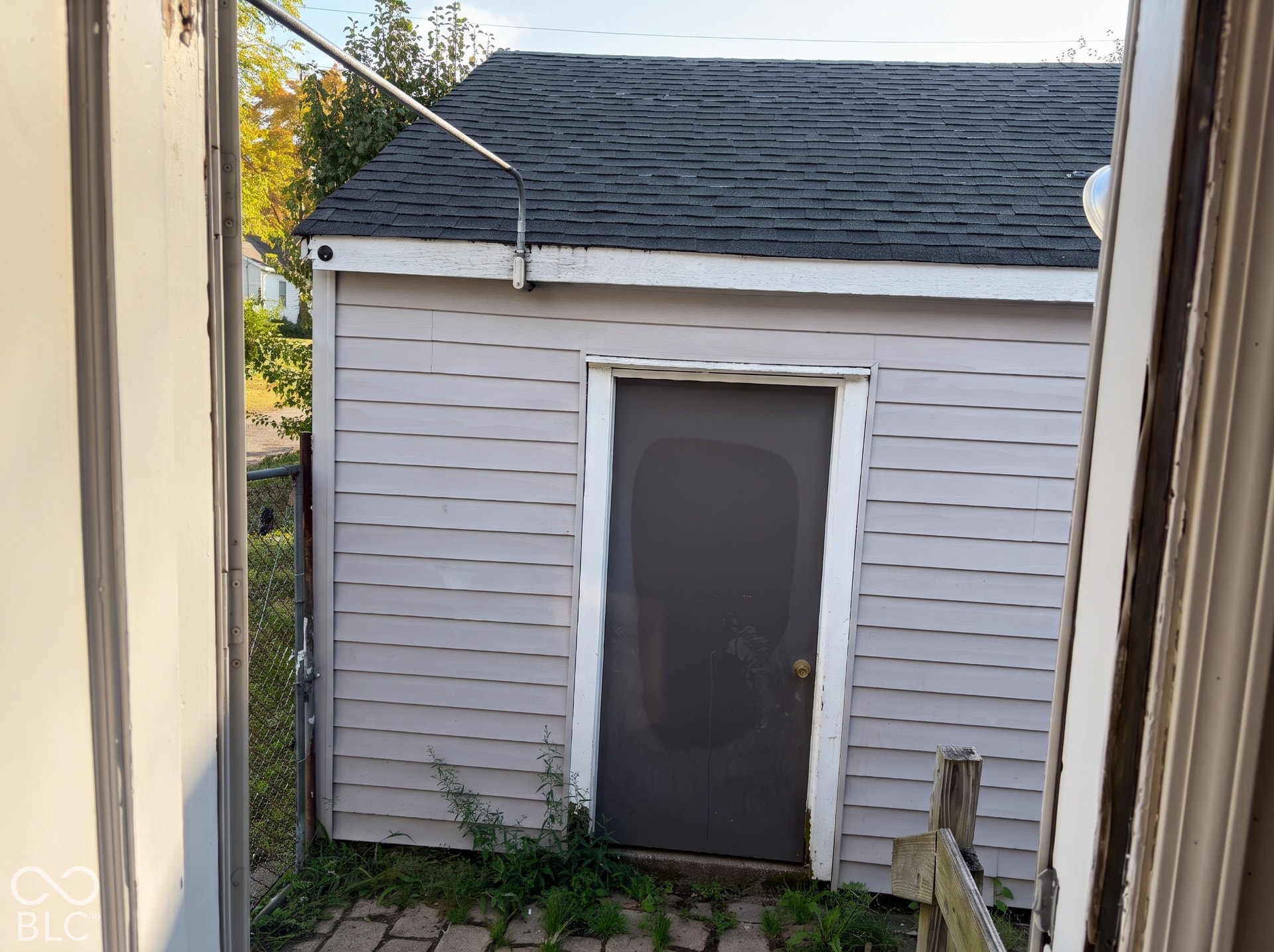 Outbuilding featuring horizontal siding and an asphalt shingle roof