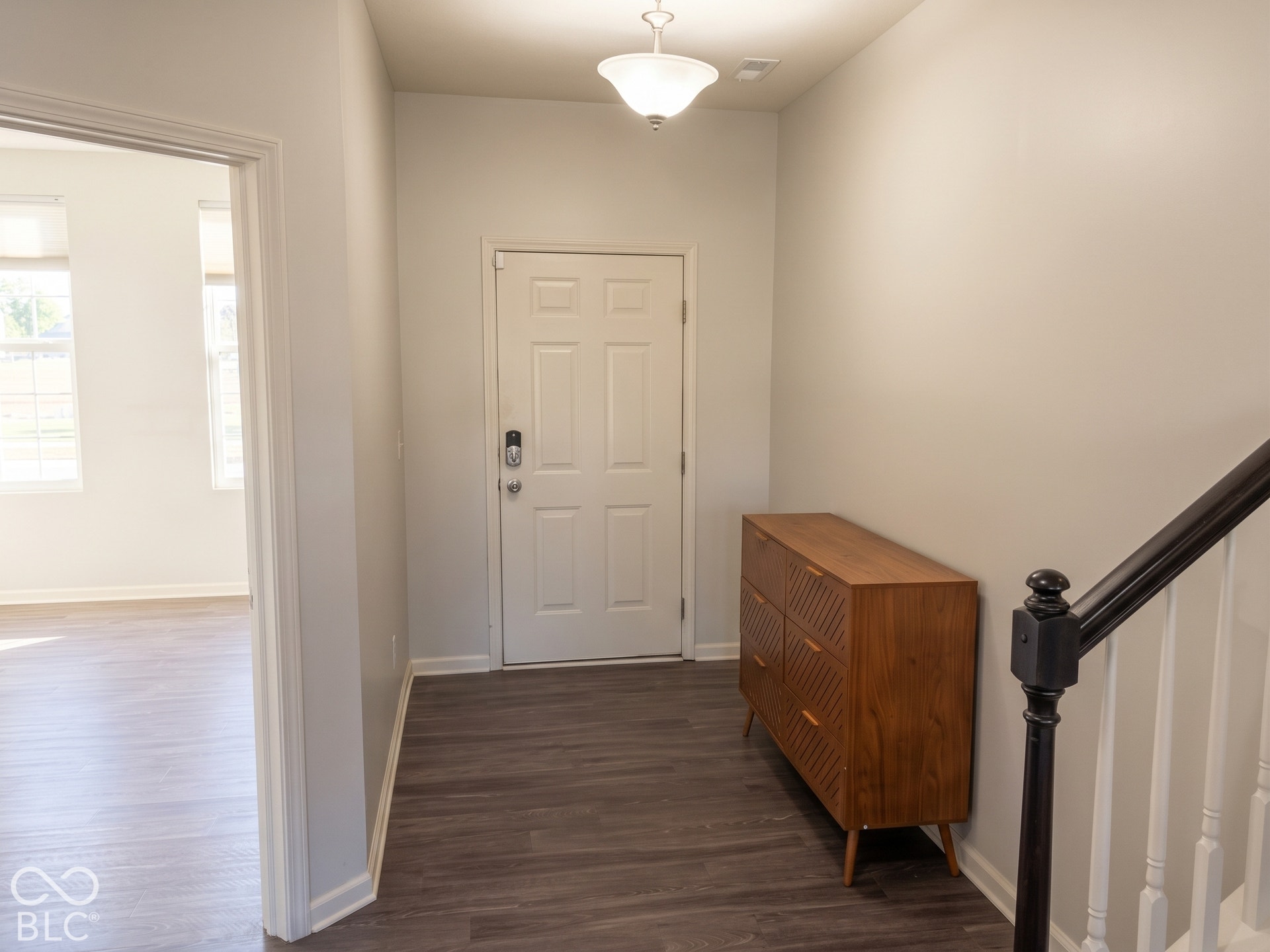 Virtually Altered - Entryway featuring wood-finish flooring, a white paneled door and a semi-flush mount ceiling light