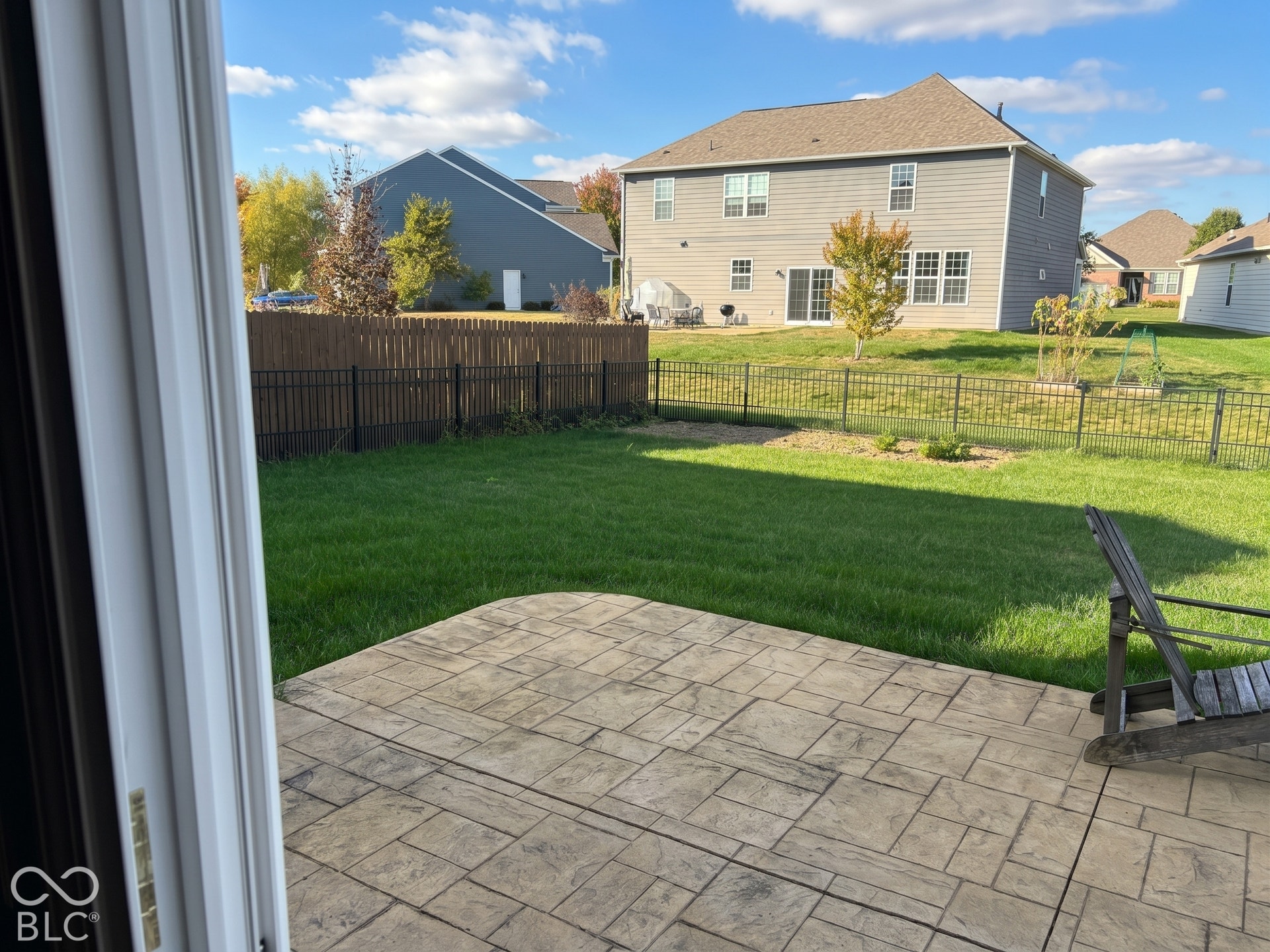 Virtually Altered - Stamped concrete patio opening to a fenced backyard