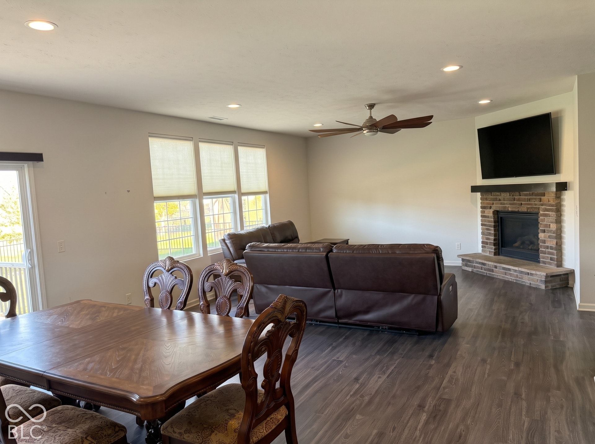 Virtually Altered - Recessed lighting, wood-finish flooring, ceiling fan, brick fireplace, and multiple windows