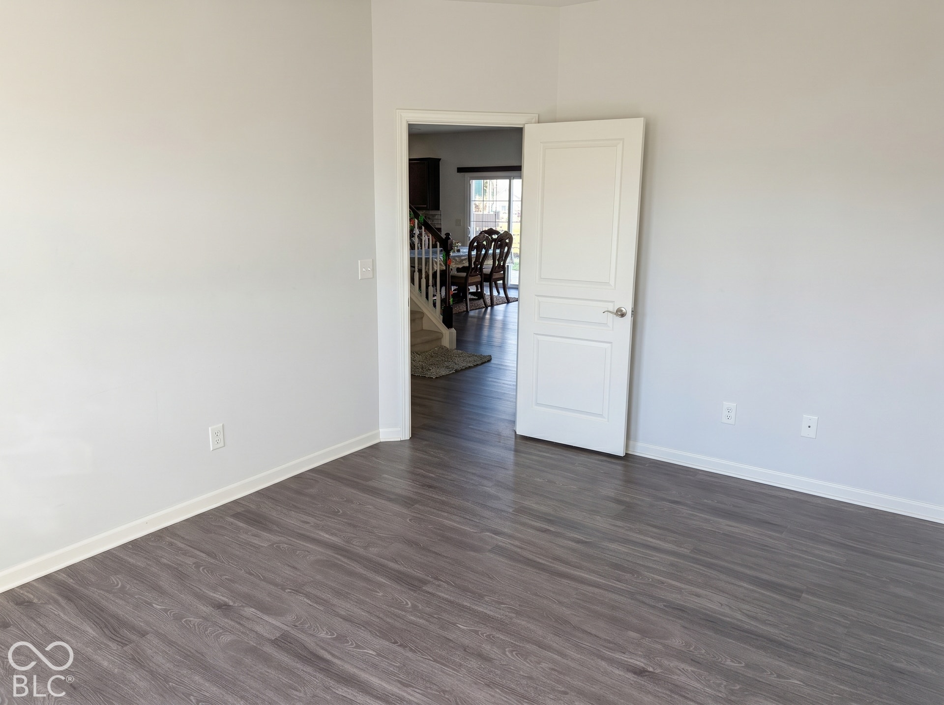 Virtually Altered - Wood-finish flooring with a neutral wall color and white trim