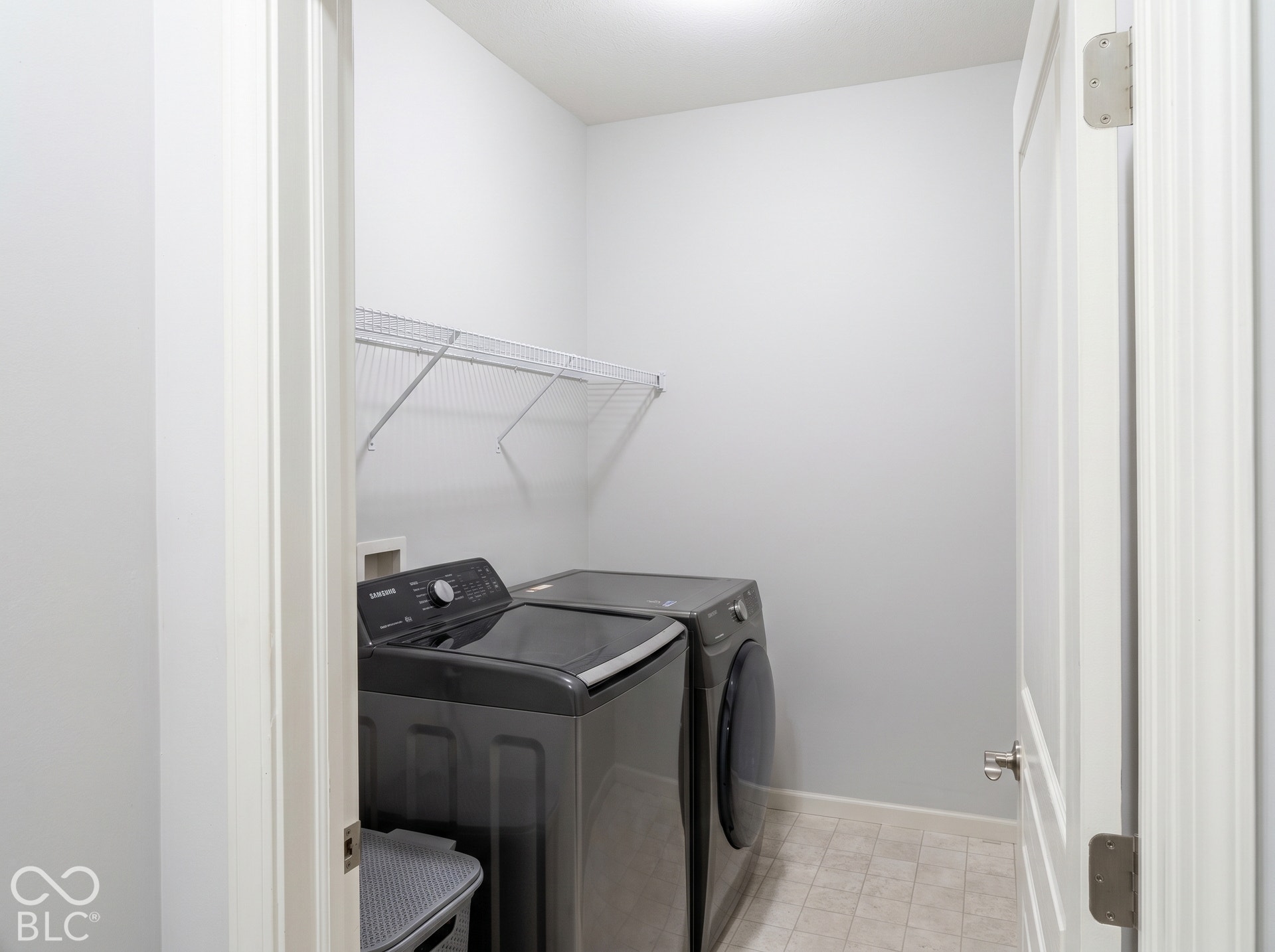 Virtually Altered - Recessed lighting illuminates a utility space featuring wire shelving and light-toned flooring