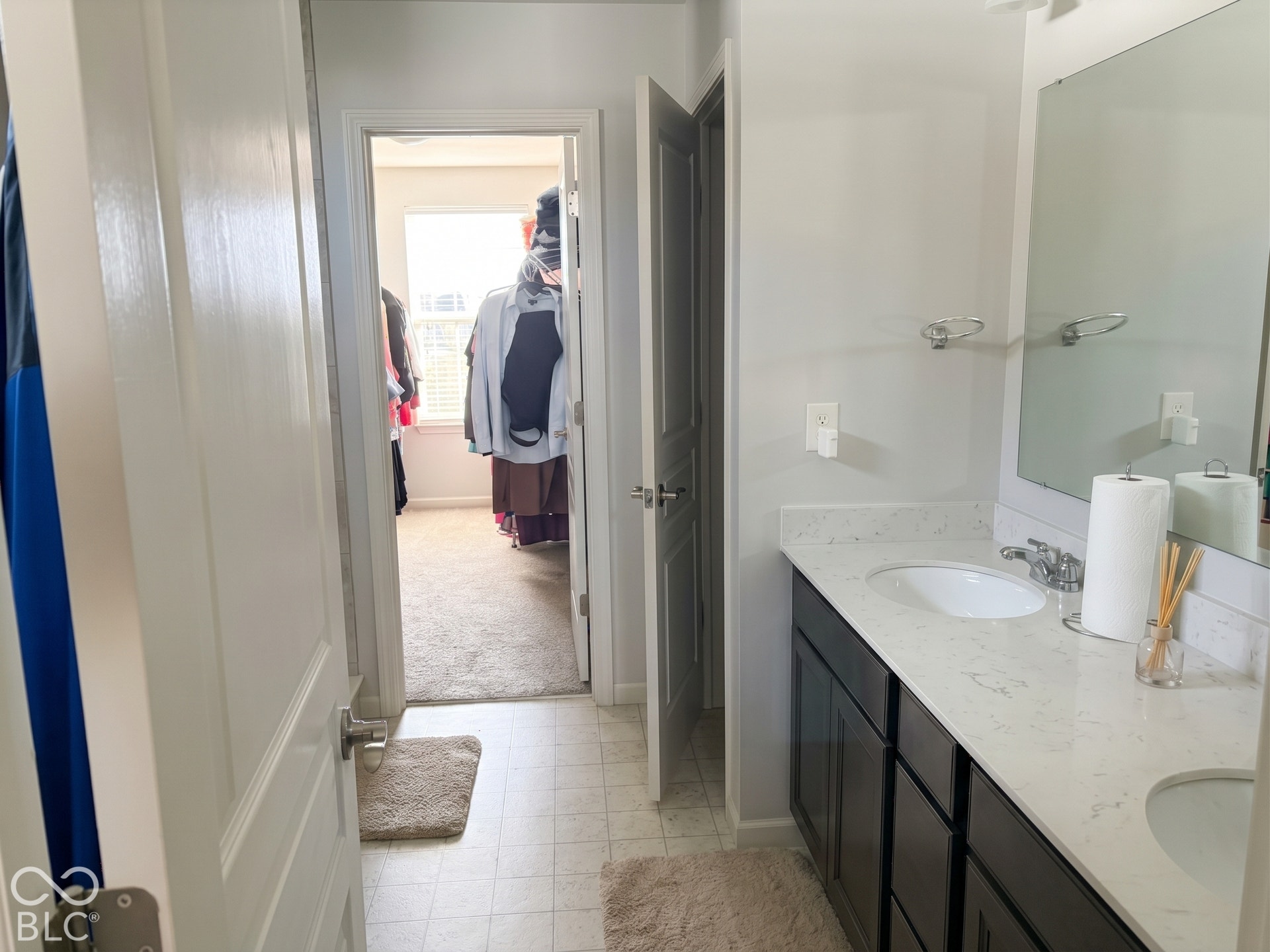 Virtually Altered - Master bathroom with dual vanity with white undermount sinks, chrome fixtures, and a granite countertop