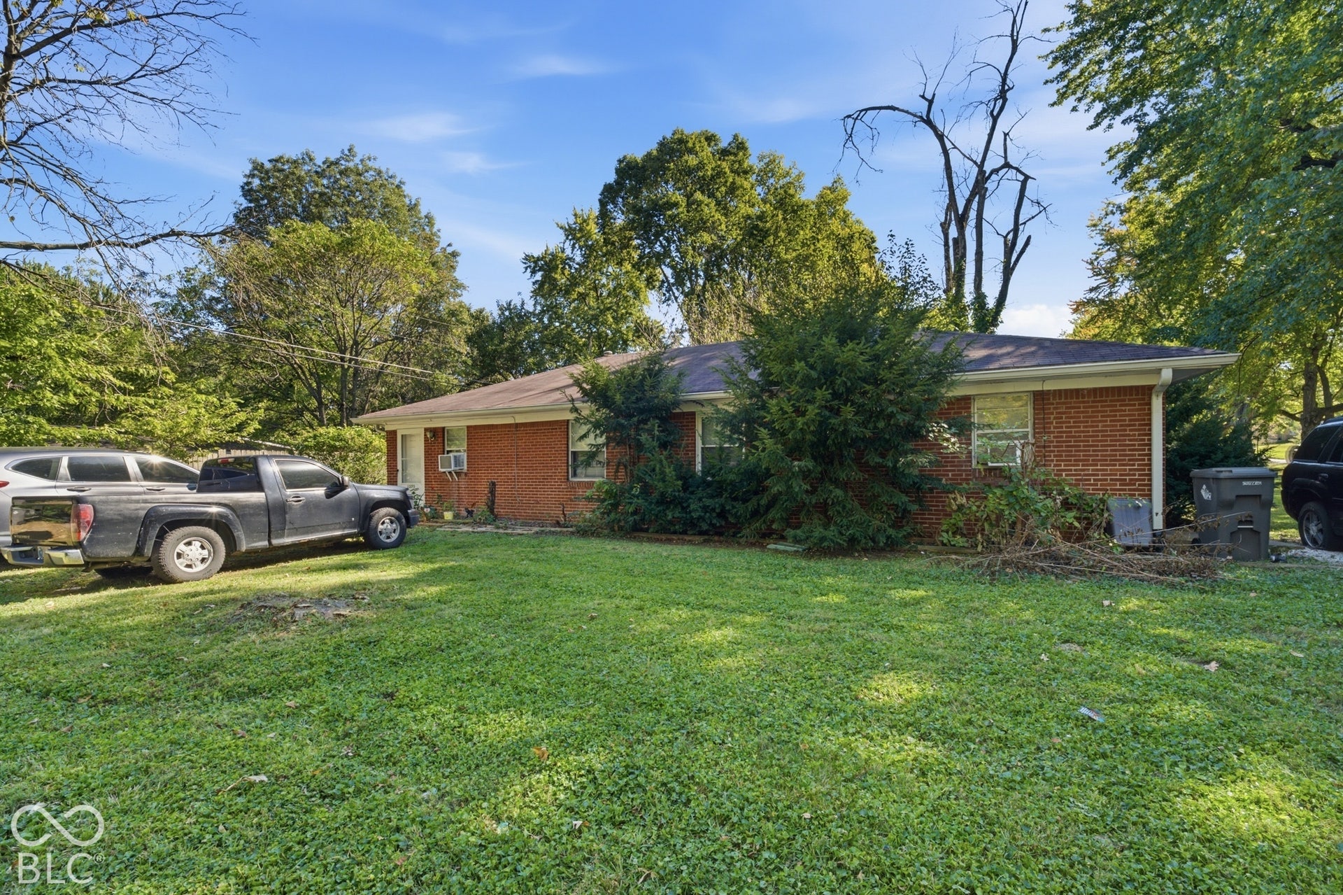 1273 Farley, Indianapolis, IN 46214 Brick exterior construction, gabled roof, mature landscaping, window air conditioning unit