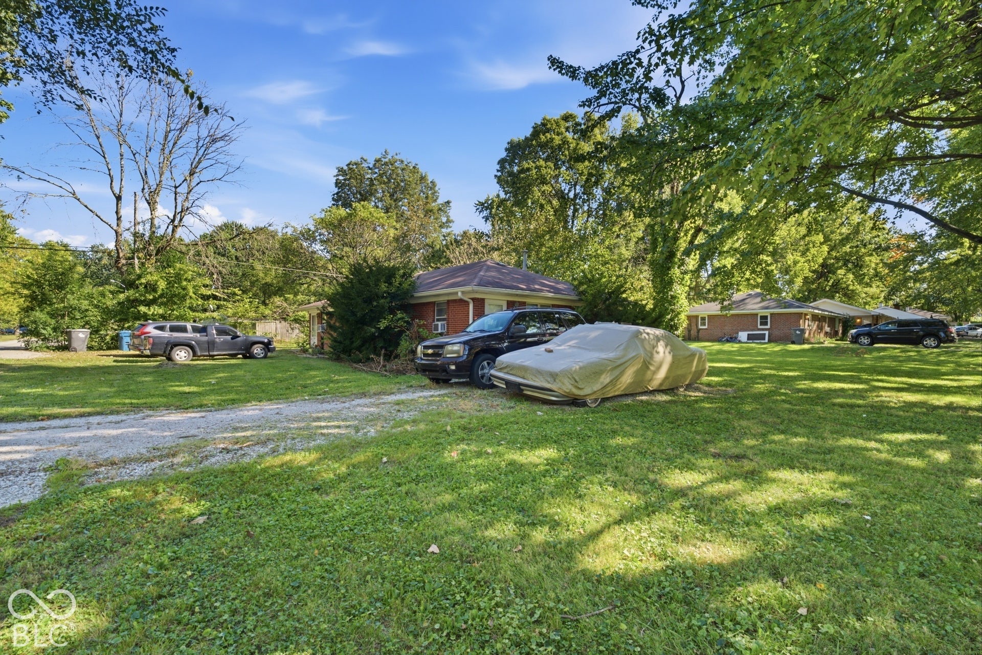 1273 Farley, Indianapolis, IN 46214 Gravel driveway with a grassy expanse and mature trees