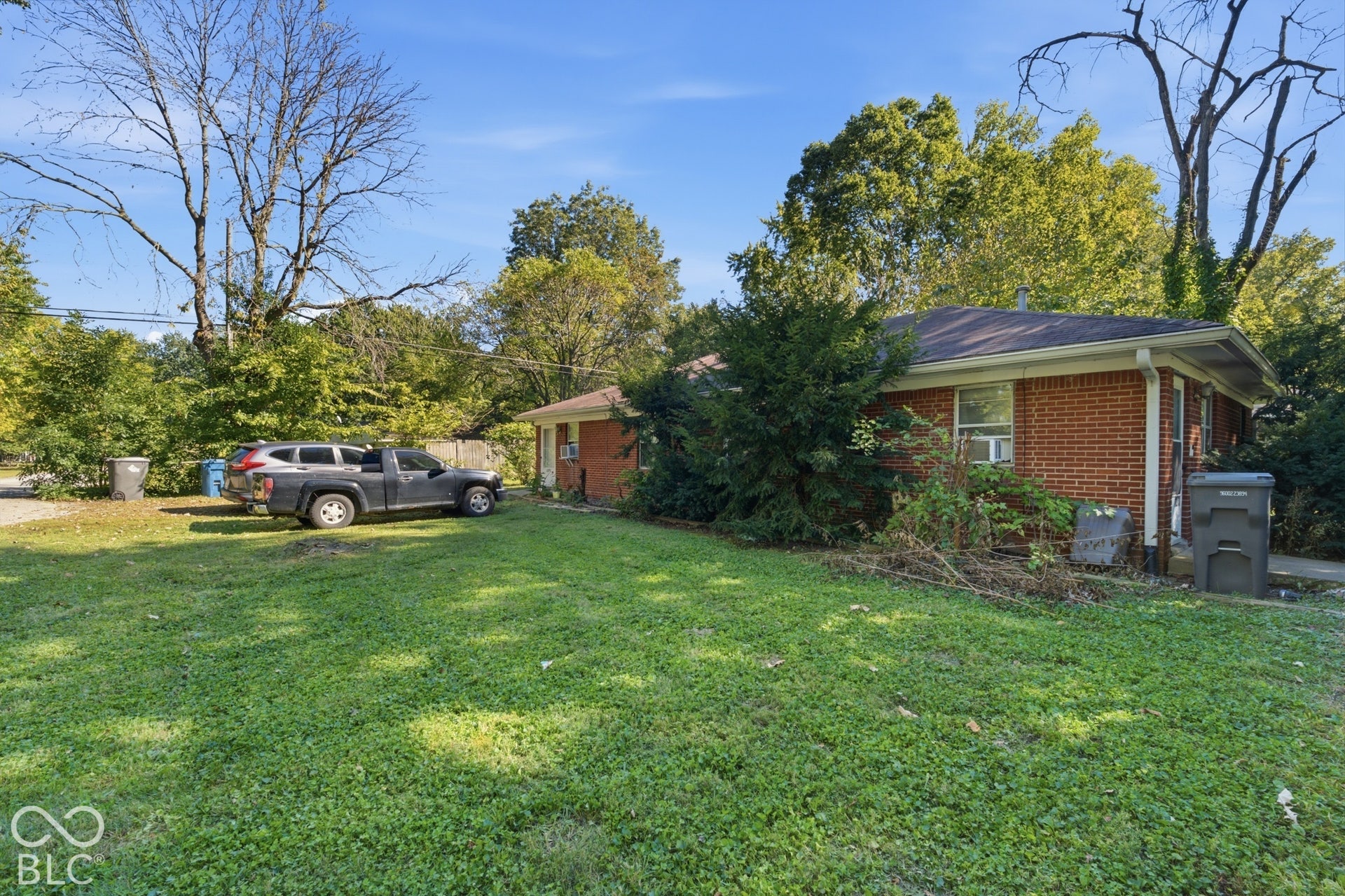 1273 Farley, Indianapolis, IN 46214 Brick exterior with a gabled roofline and an expansive grassy yard