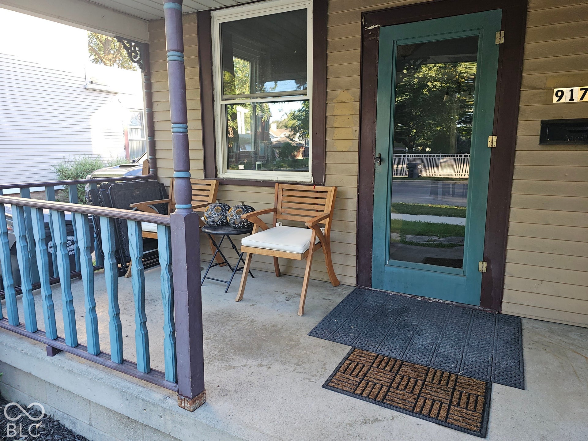 917 W 8th Street, Anderson, IN 46016 Front porch featuring painted wood railings and a glass-paneled entry door