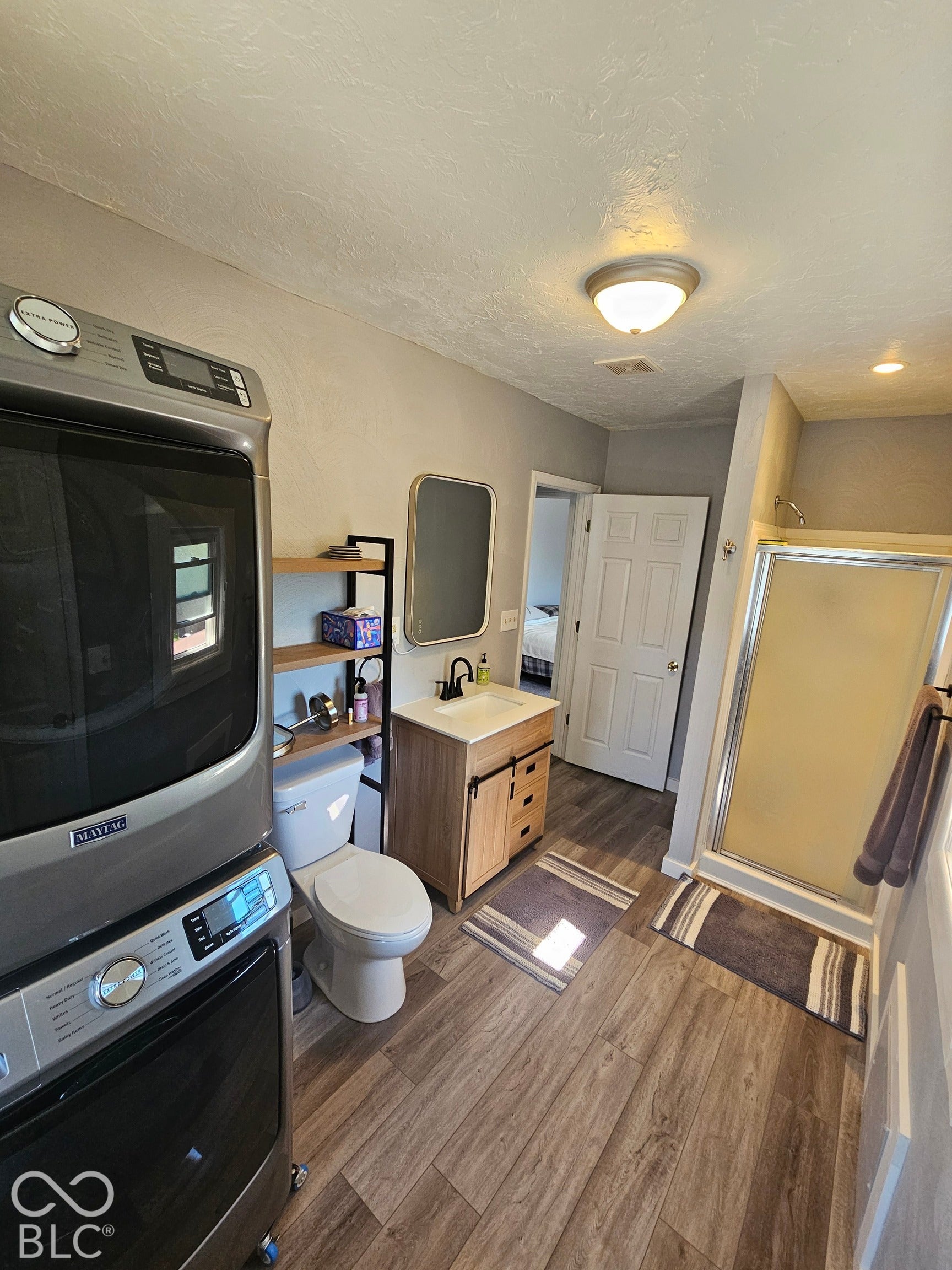917 W 8th Street, Anderson, IN 46016 Wood-finish flooring throughout, vanity with a white countertop and black-finish faucet, and a shower enclosure