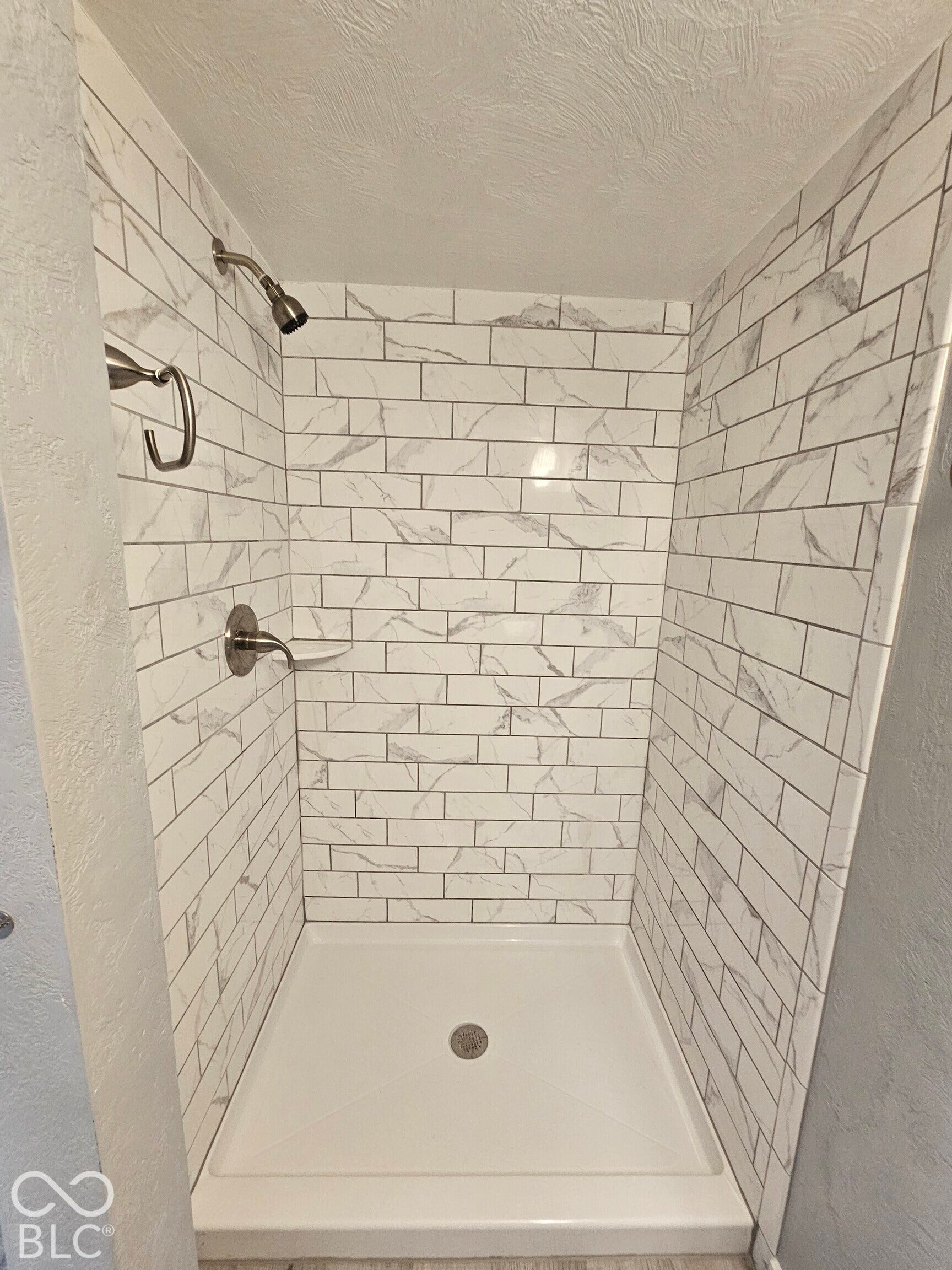 917 W 8th Street, Anderson, IN 46016 Subway tile shower surround with a white finish, brushed nickel fixtures, and a white shower pan