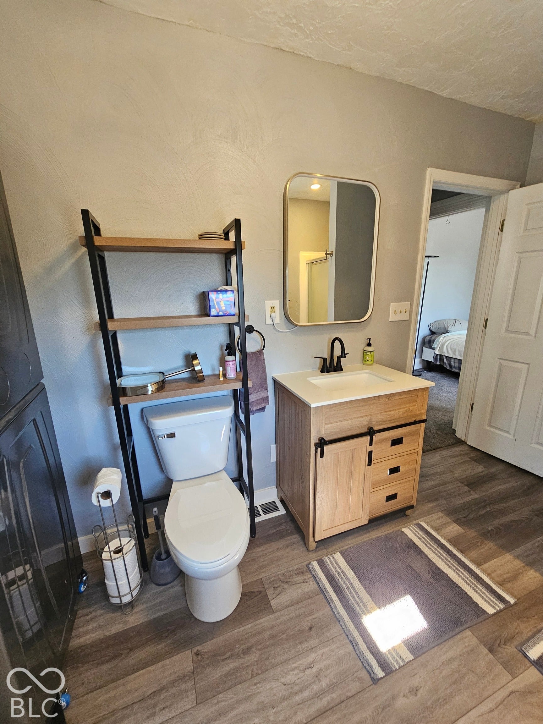 917 W 8th Street, Anderson, IN 46016 Wood-finish flooring, light-toned walls, and a modern vanity with a rectangular sink
