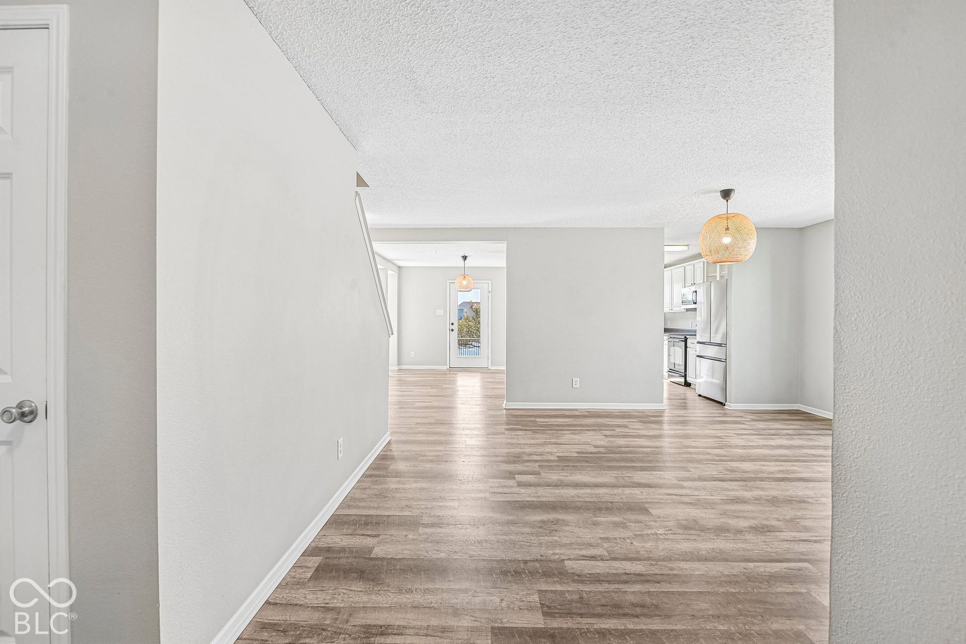 Wood-finish flooring throughout, light gray wall tones, and modern light fixtures