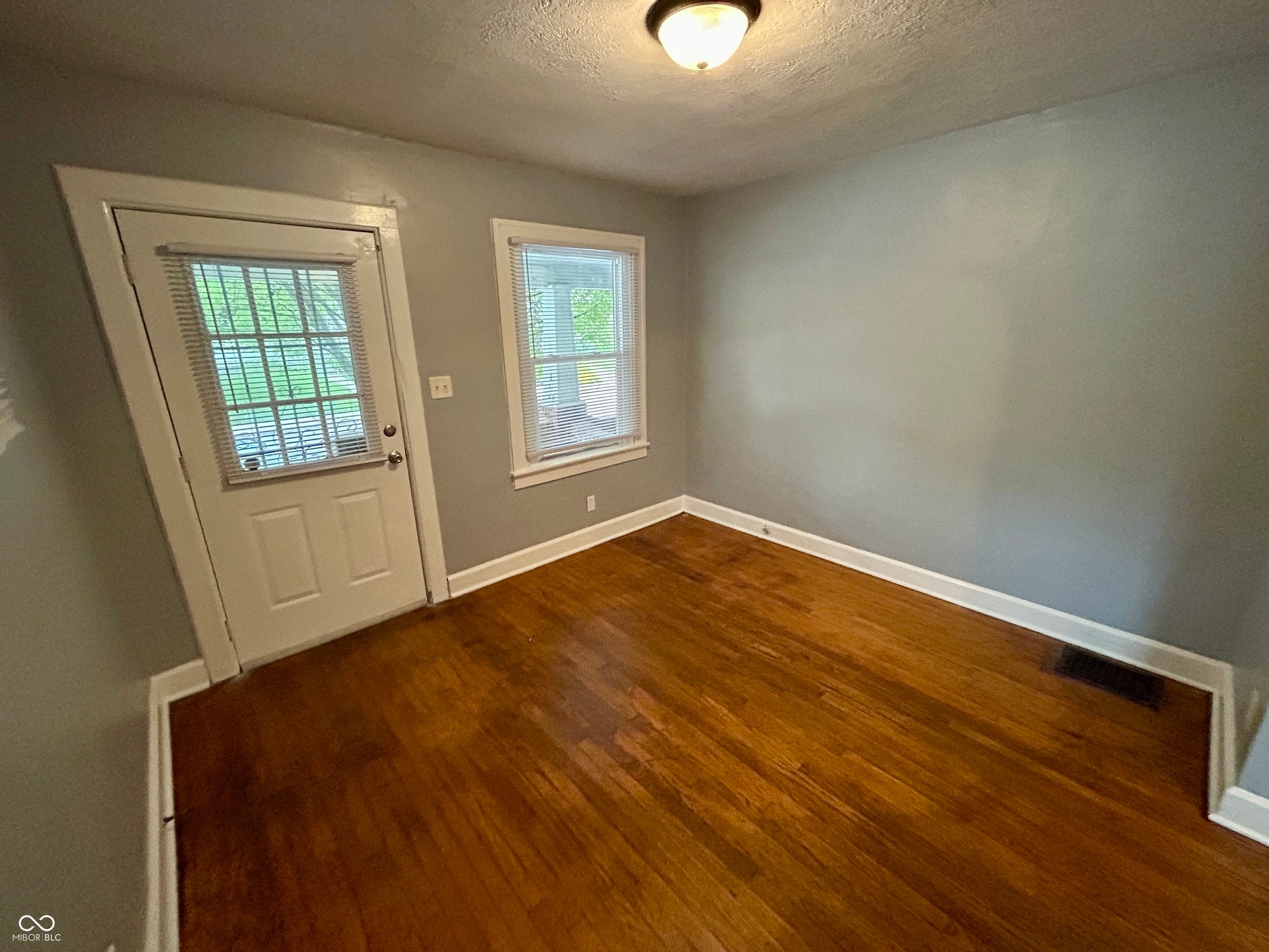 Hardwood flooring throughout, complemented by light gray wall paint and white trim