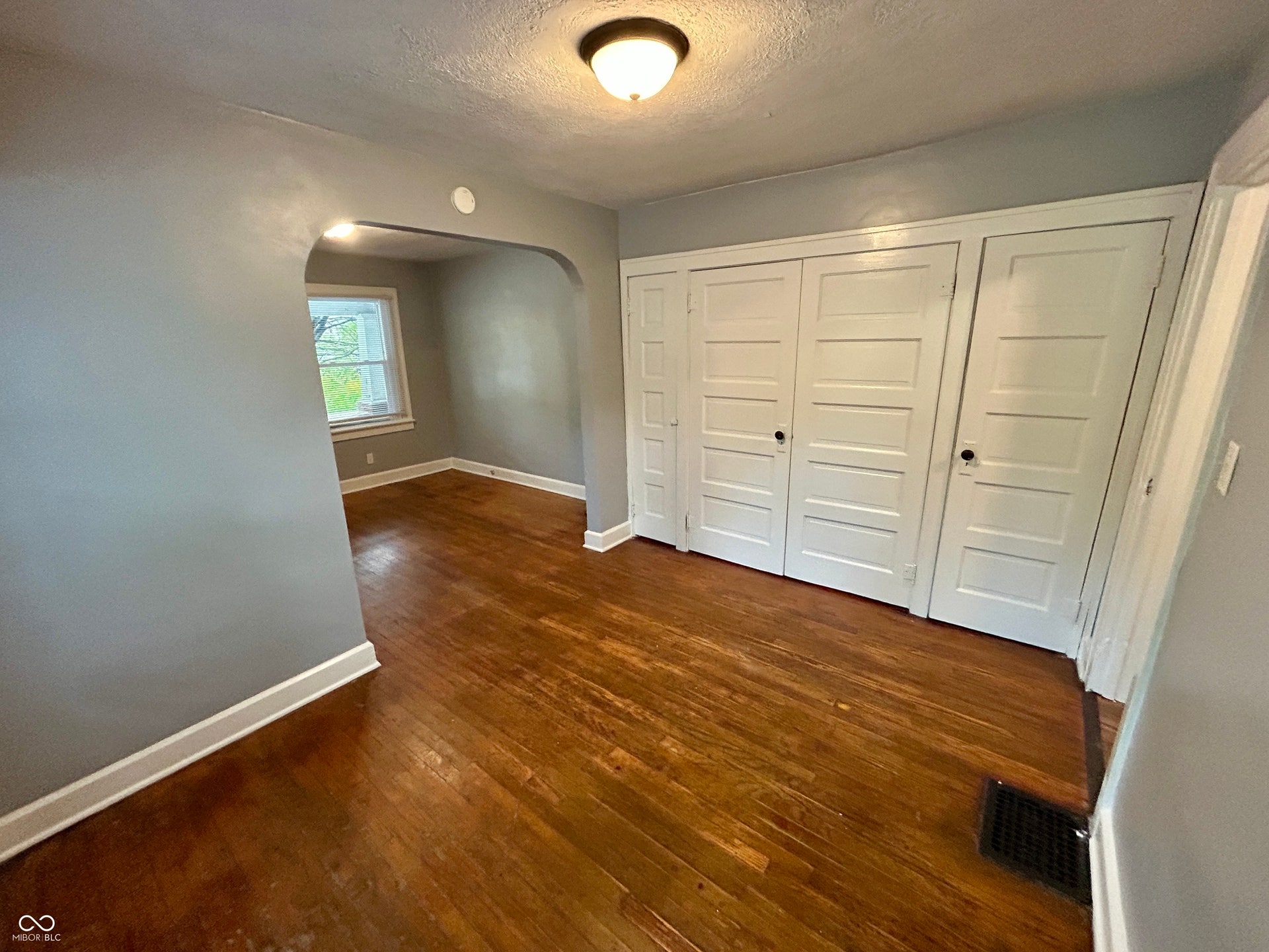 Hardwood flooring highlights this room with a built-in wall of four-panel doors