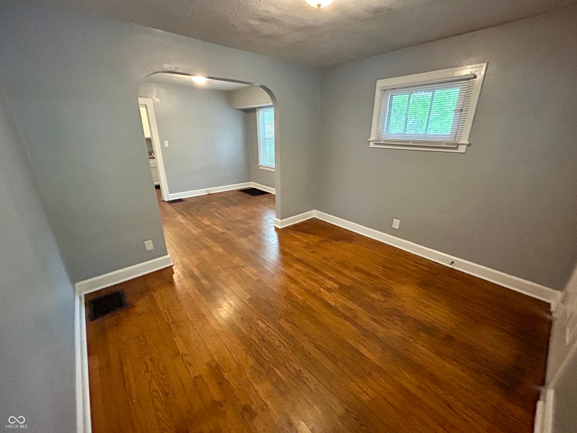 Hardwood flooring throughout the room, complemented by neutral gray walls and white baseboards