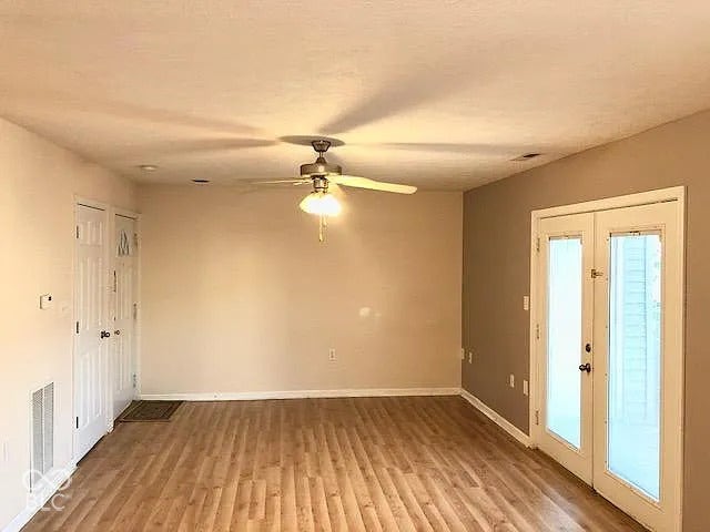 Wood-finish flooring, ceiling fan with integrated lighting, dual pane French doors, recessed ceiling lighting, and neutral wall tones