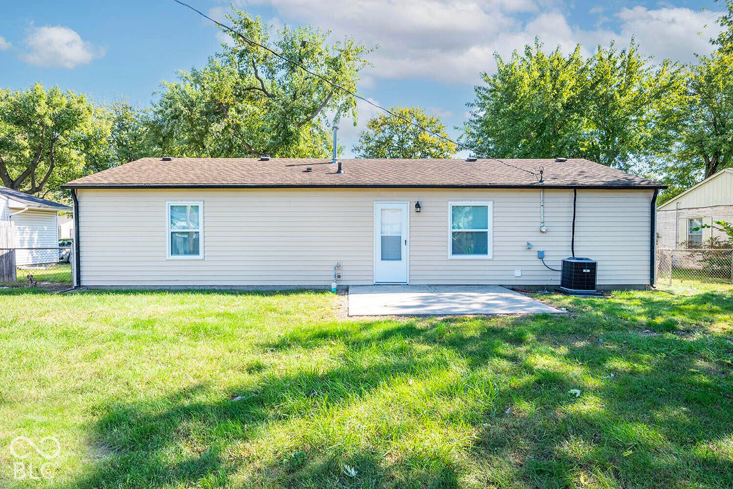Rear exterior featuring horizontal siding, a private entry door, a concrete patio, and a compact HVAC unit
