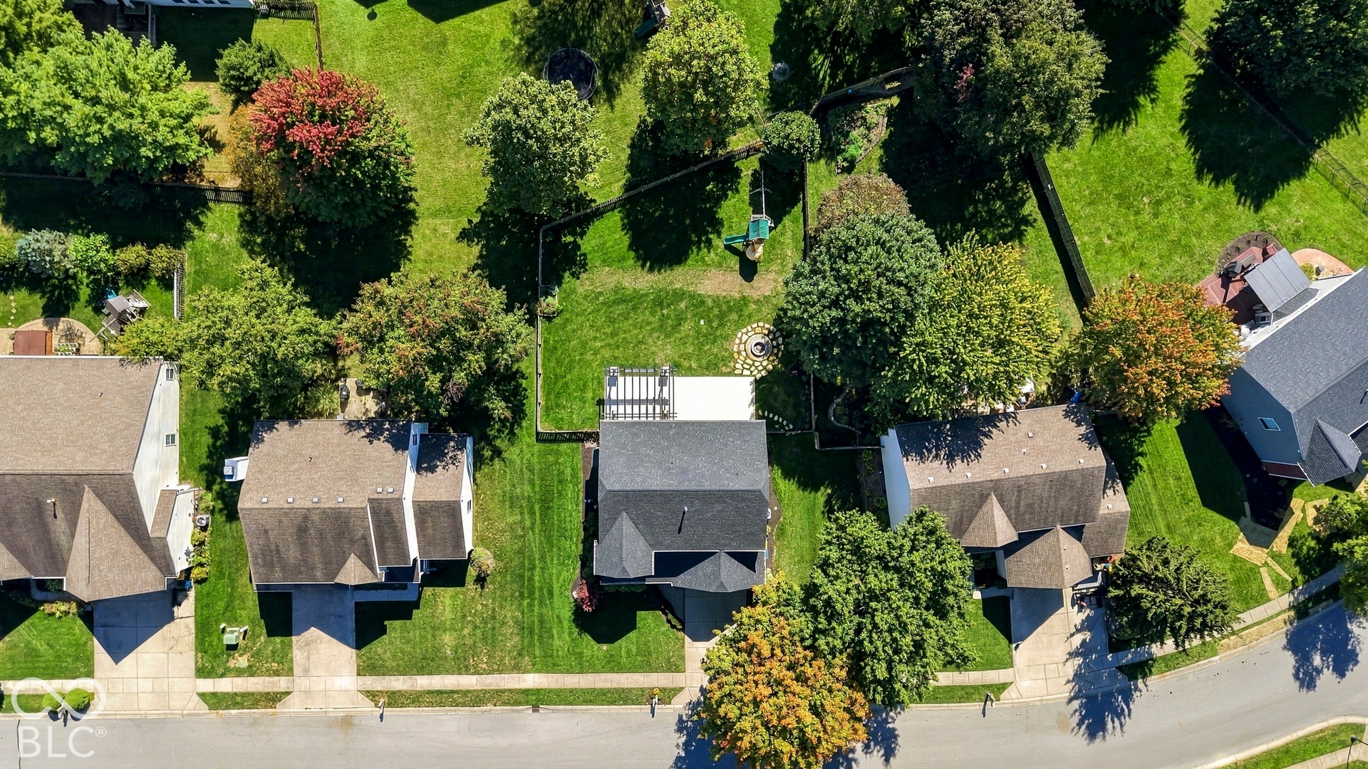 Expansive green spaces with mature trees and a fenced rear yard