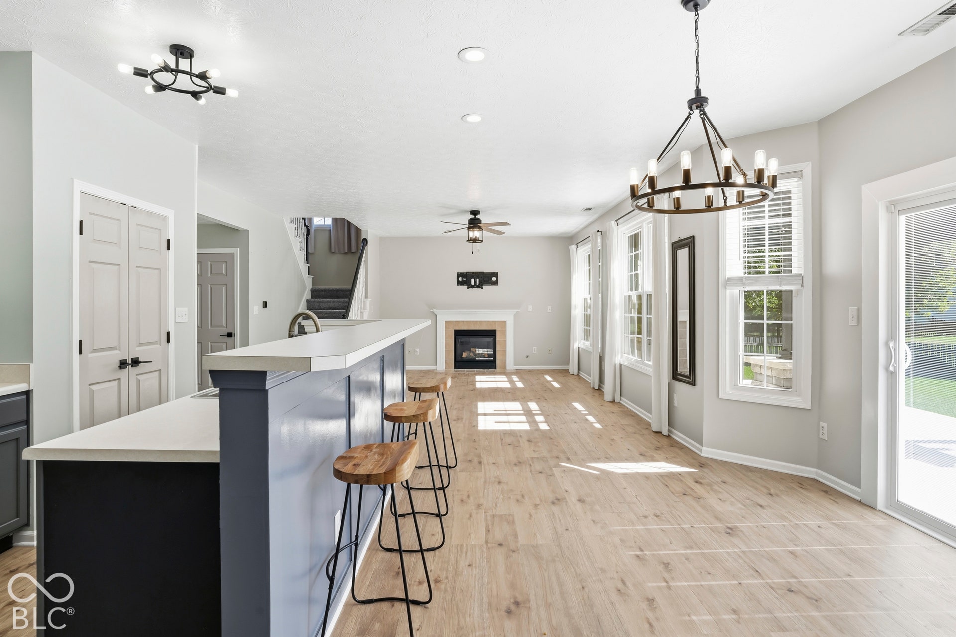 Spacious open-concept living area featuring a contemporary fireplace, and a large sliding glass door