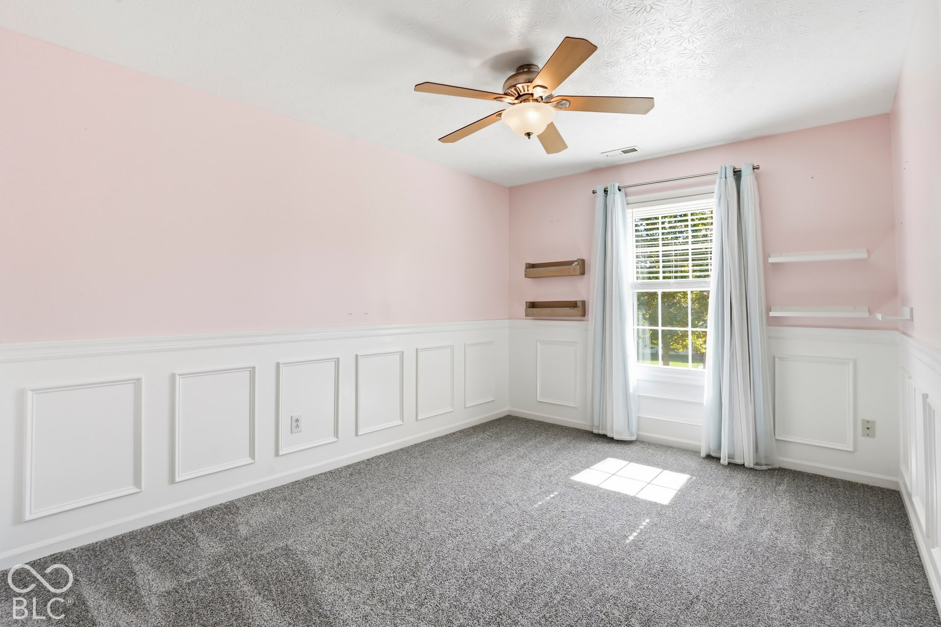 Wainscoting with decorative molding, ceiling fan with integrated lighting, window with blinds
