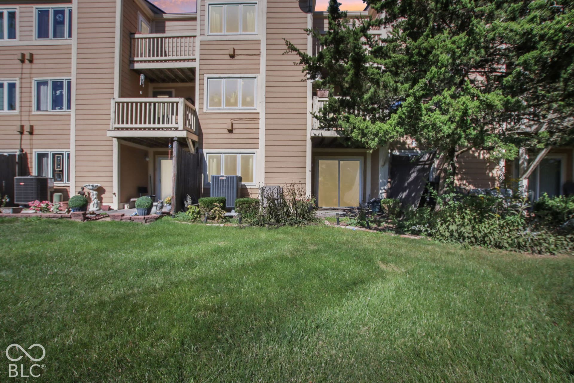 Virtually Altered - Manicured lawn with a brick retaining wall and mature trees