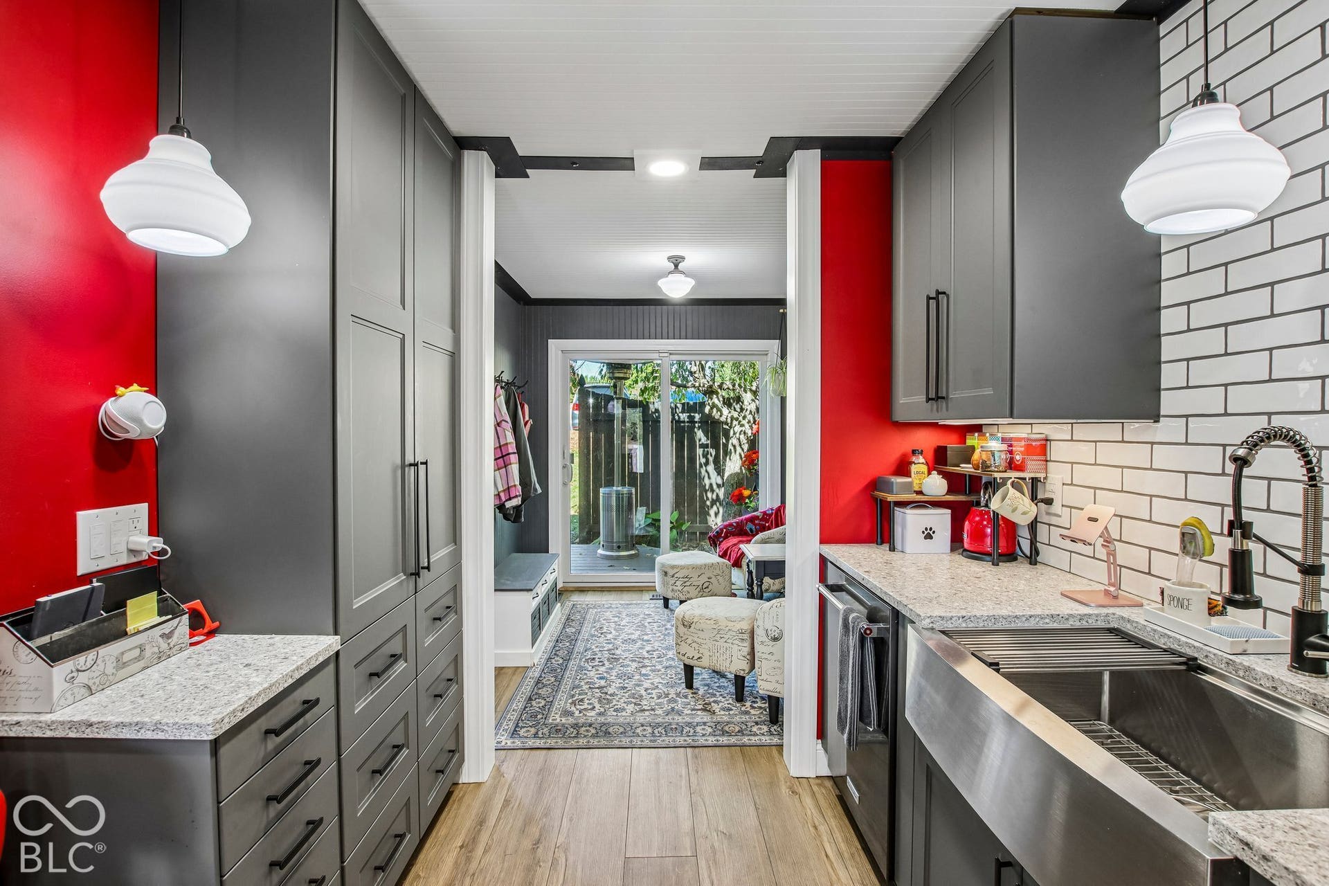 Modern kitchen cabinetry with matte black hardware, granite countertops, subway tile backsplash, and a farmhouse sink