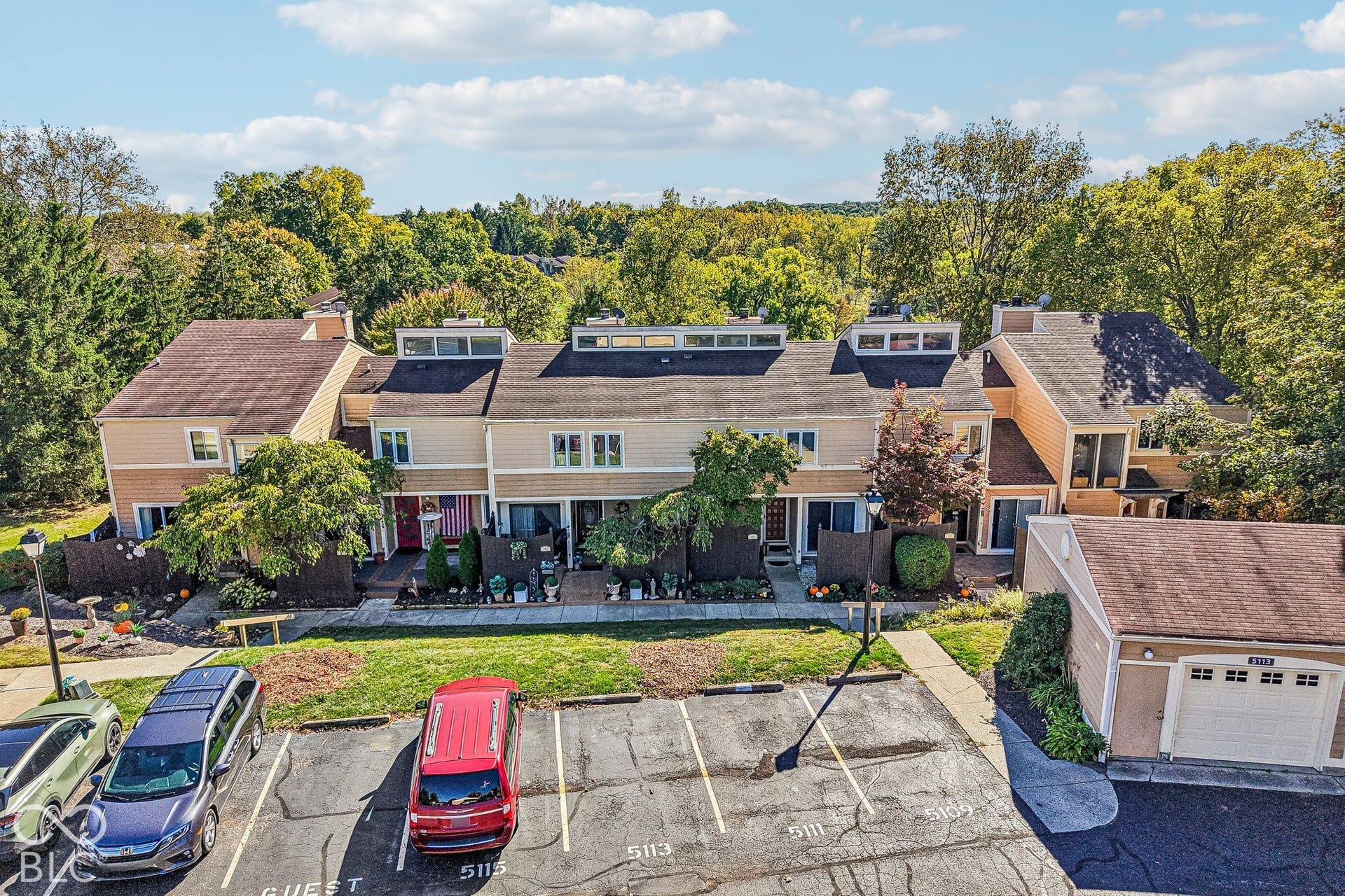 Townhome exterior featuring multi-level architecture, individual patios, and mature landscaping