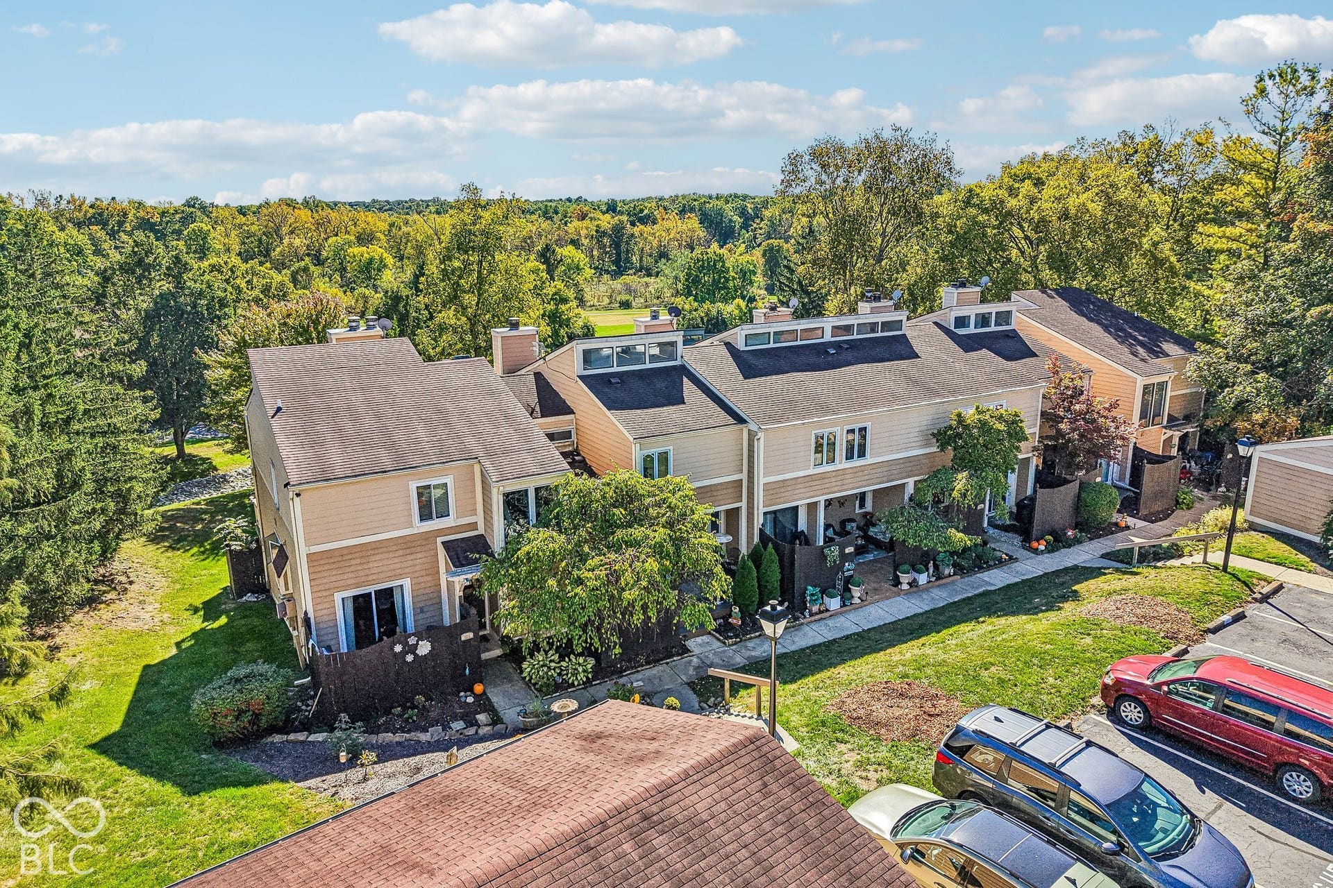 Townhome exterior with light-colored siding and dark shingle roofing