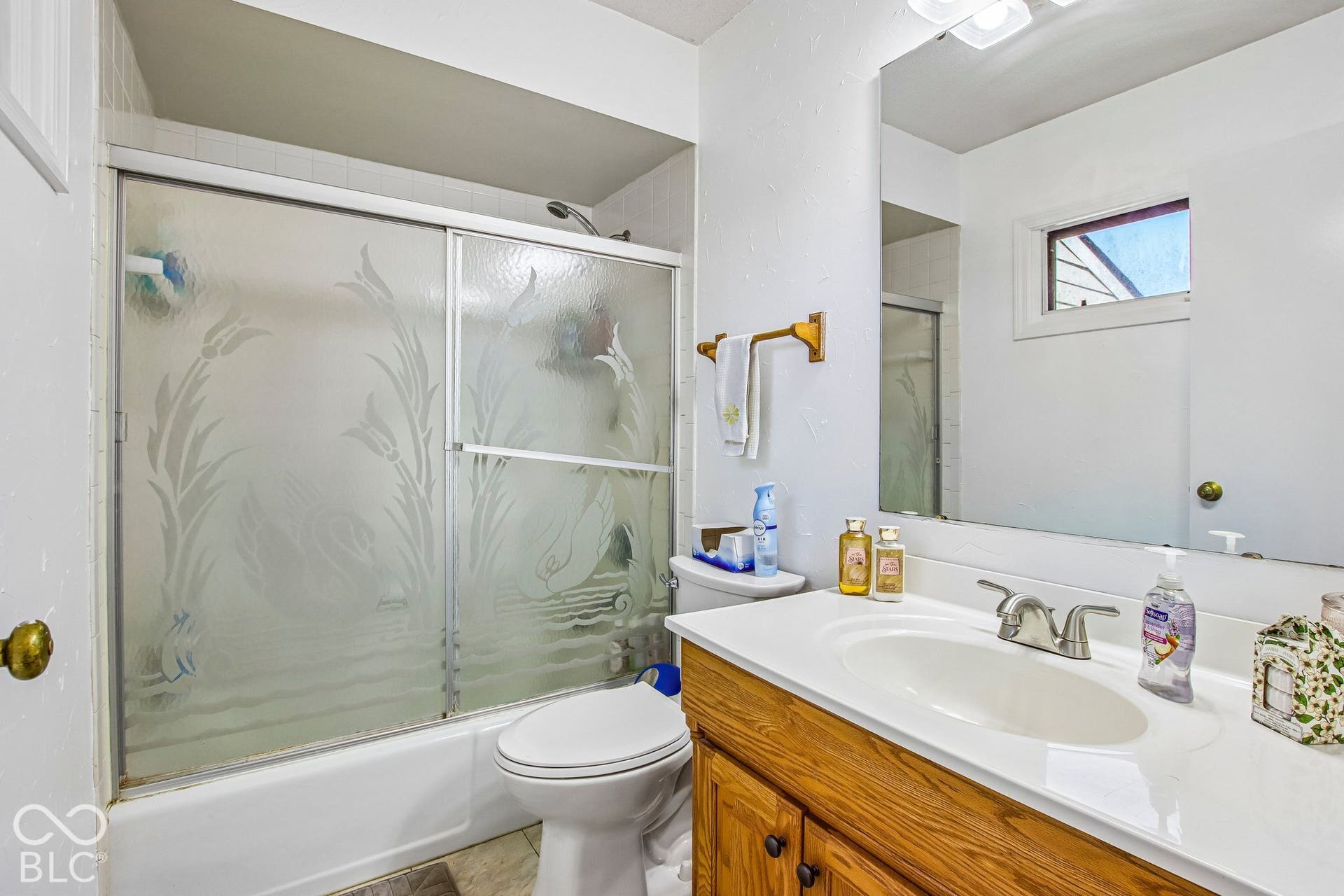 Wood-finish vanity with an integrated sink and chrome faucet