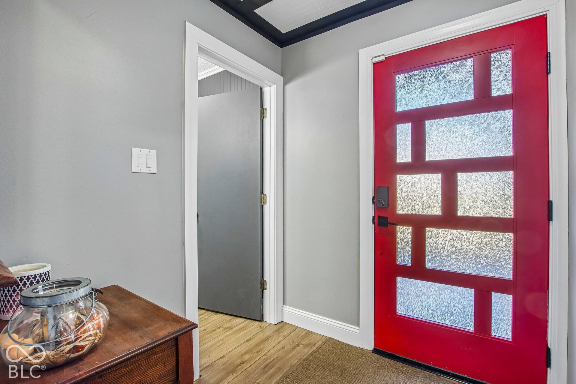 Red entry door with frosted glass panels and matte black hardware