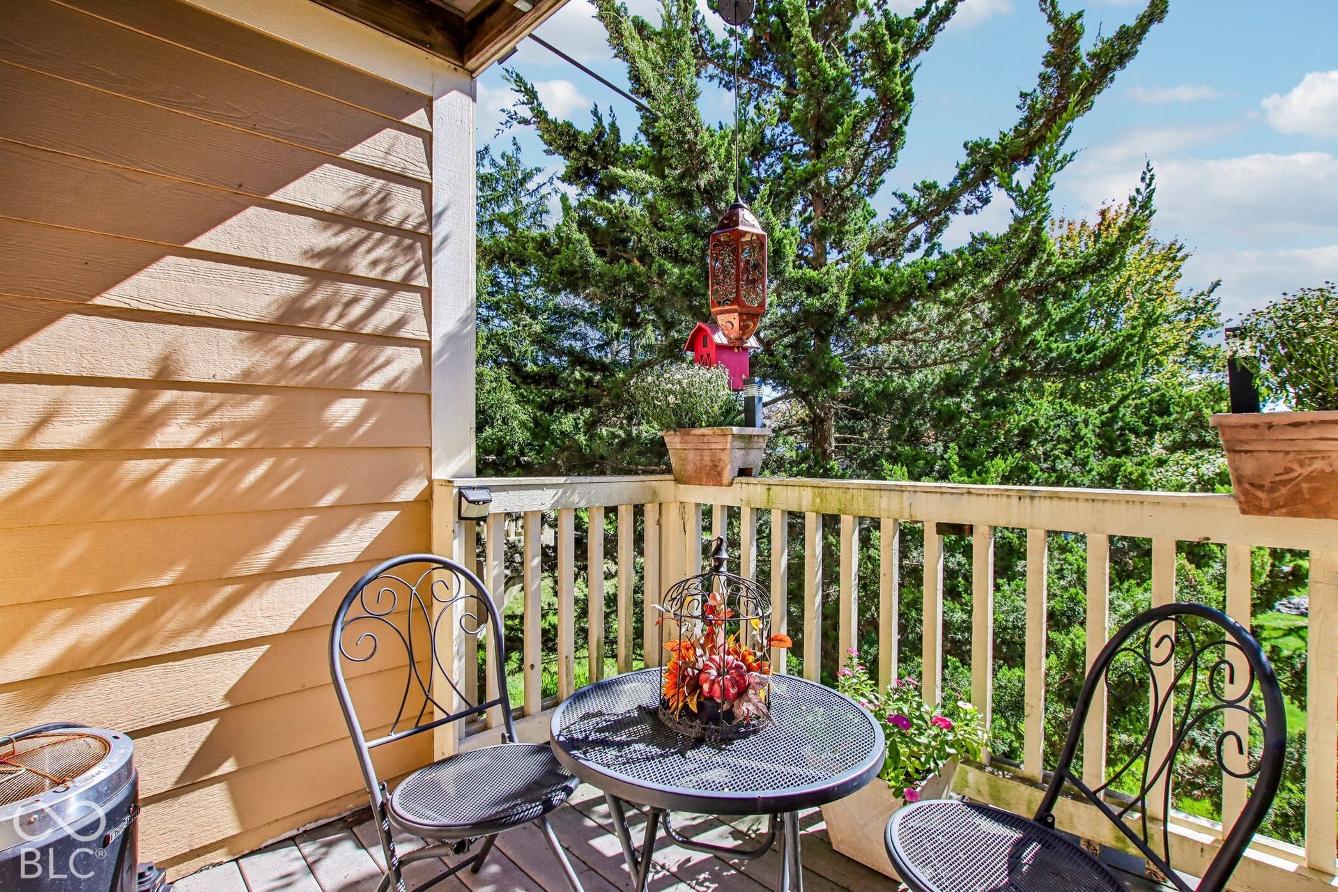 Outdoor balcony featuring wood-finish siding and a slatted wood railing
