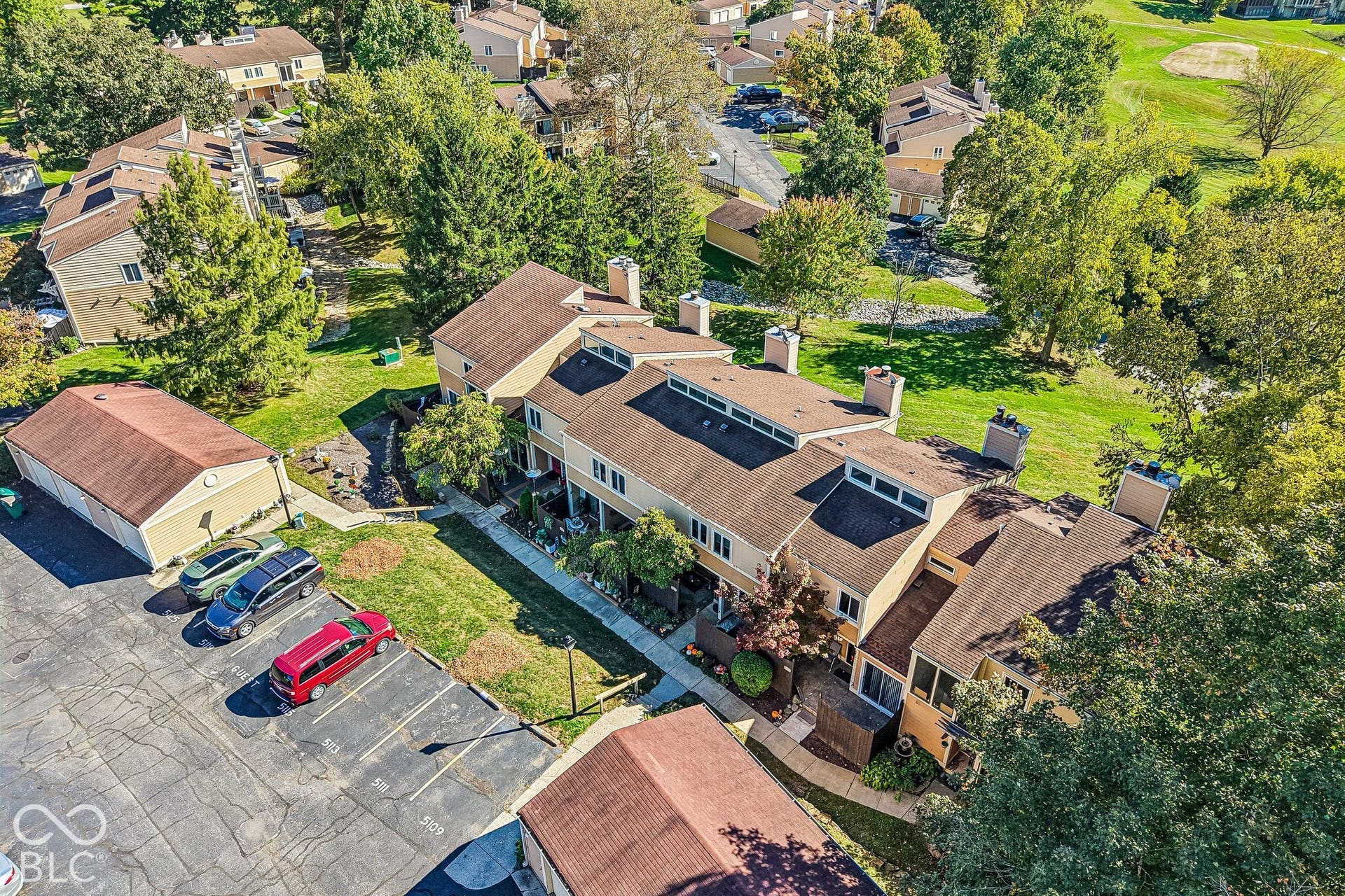 Multi-level townhouse complex with gabled roofs, multiple chimneys, and integrated skylights