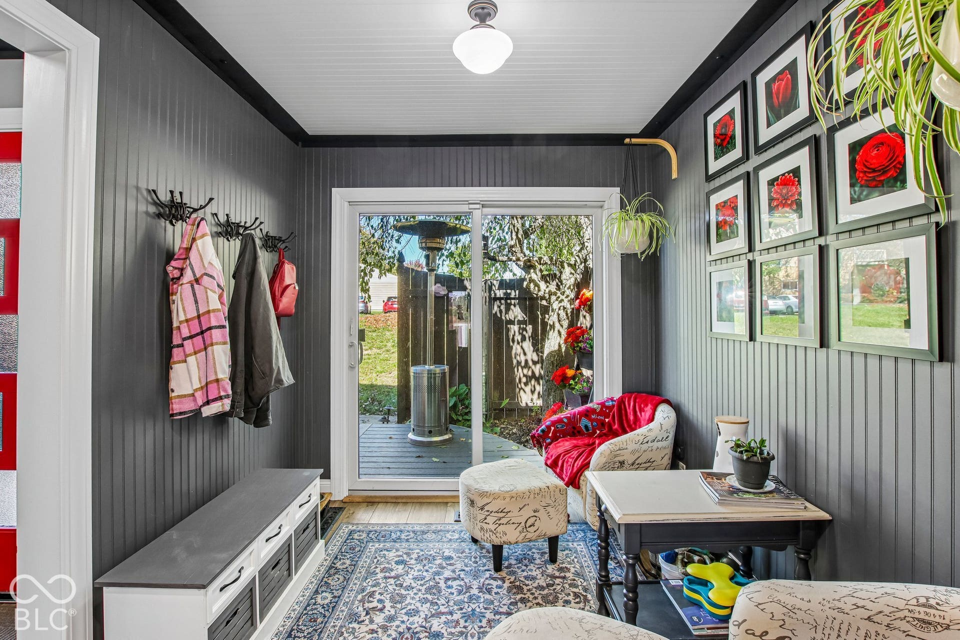 Beadboard accent wall, recessed ceiling with flush-mount lighting, and glass sliding door leading to an outdoor deck