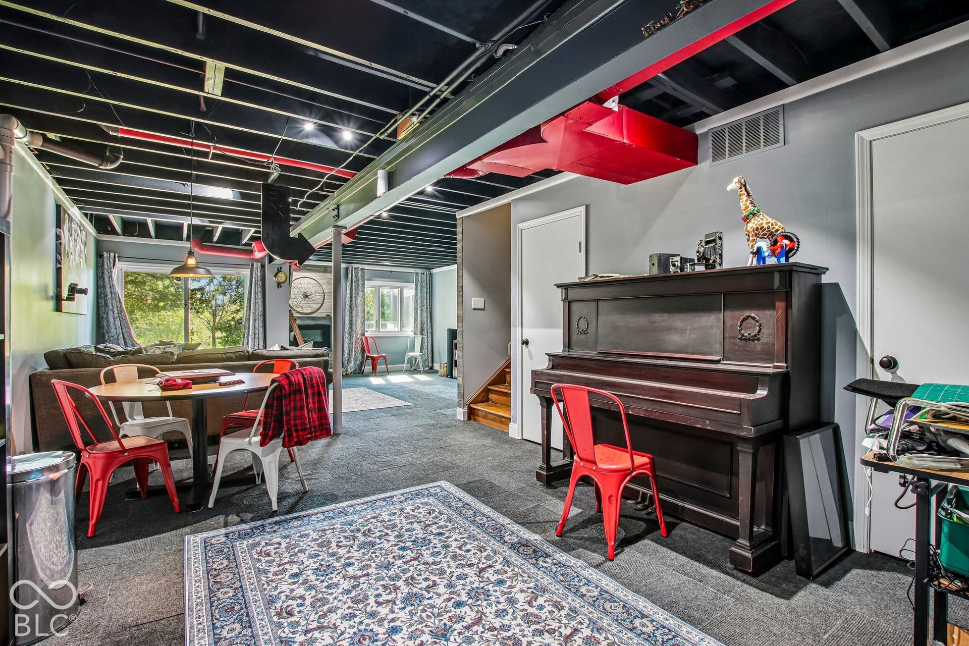 Exposed ceiling joists with painted finishes, recessed lighting, and a large window providing natural light