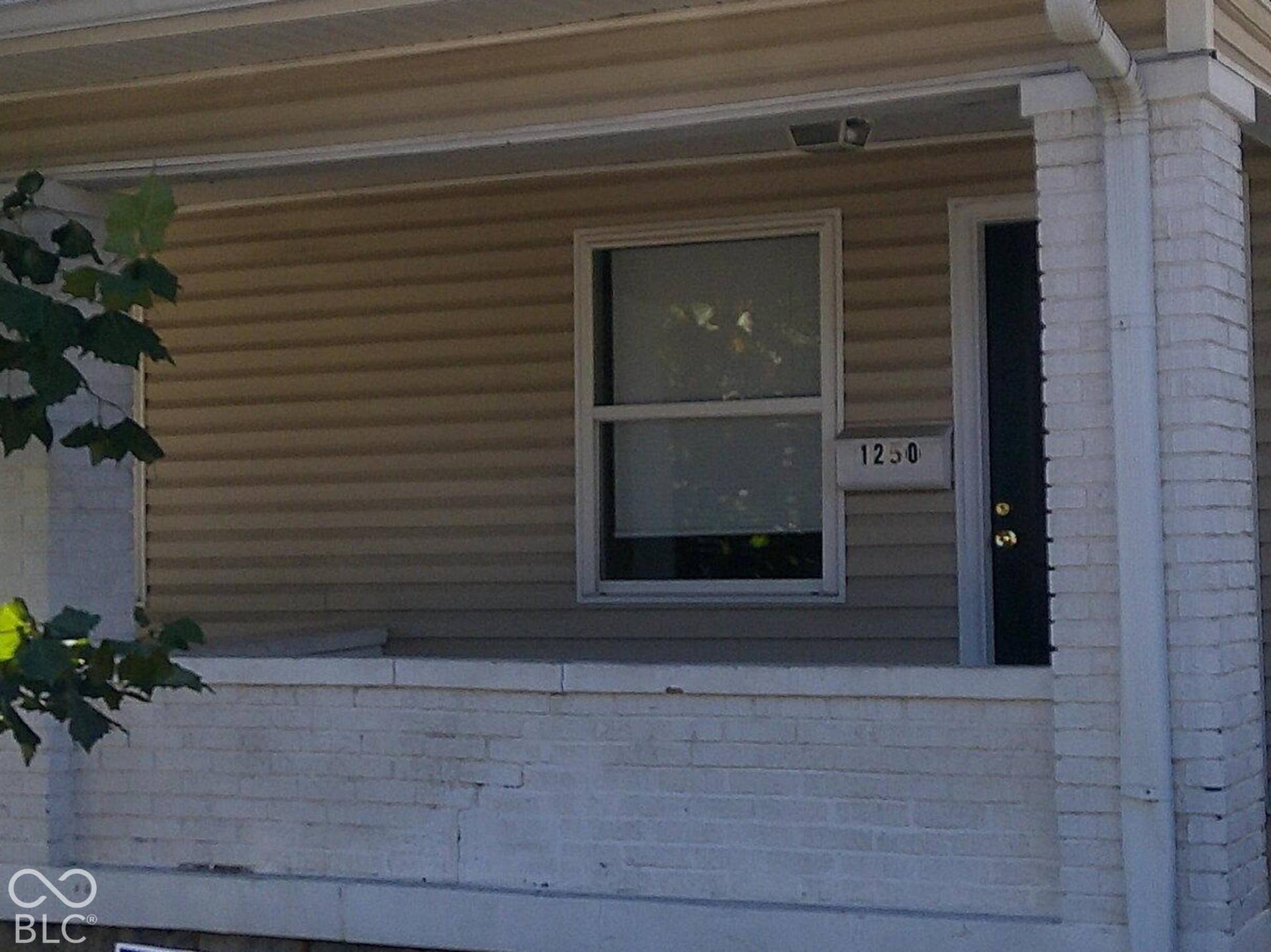 Front exterior featuring horizontal siding, a covered porch with white columns, a dark entry door, and a shingled roof