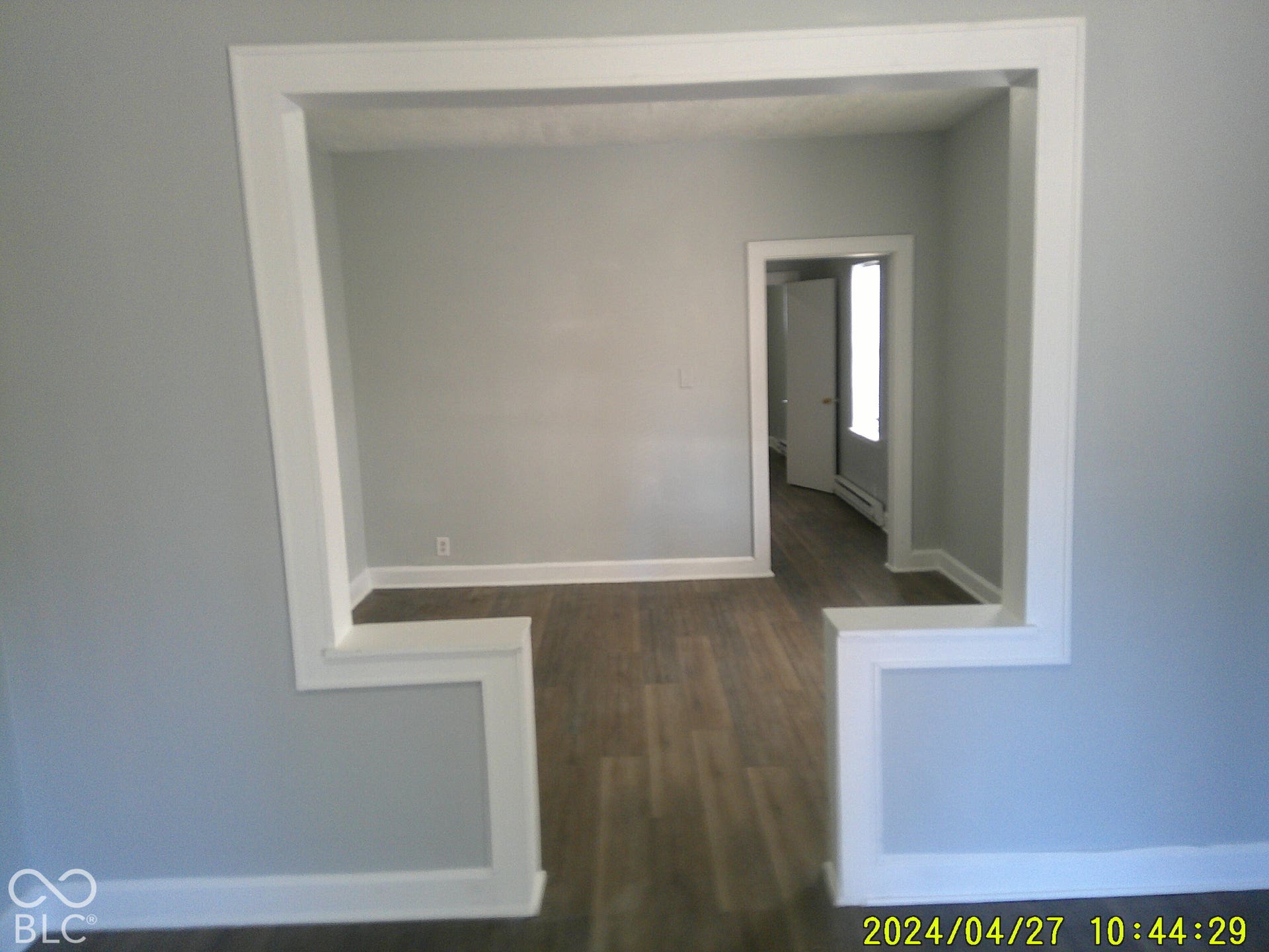 Defined entryway with wood-finish flooring, light gray wall paint, and white trim throughout