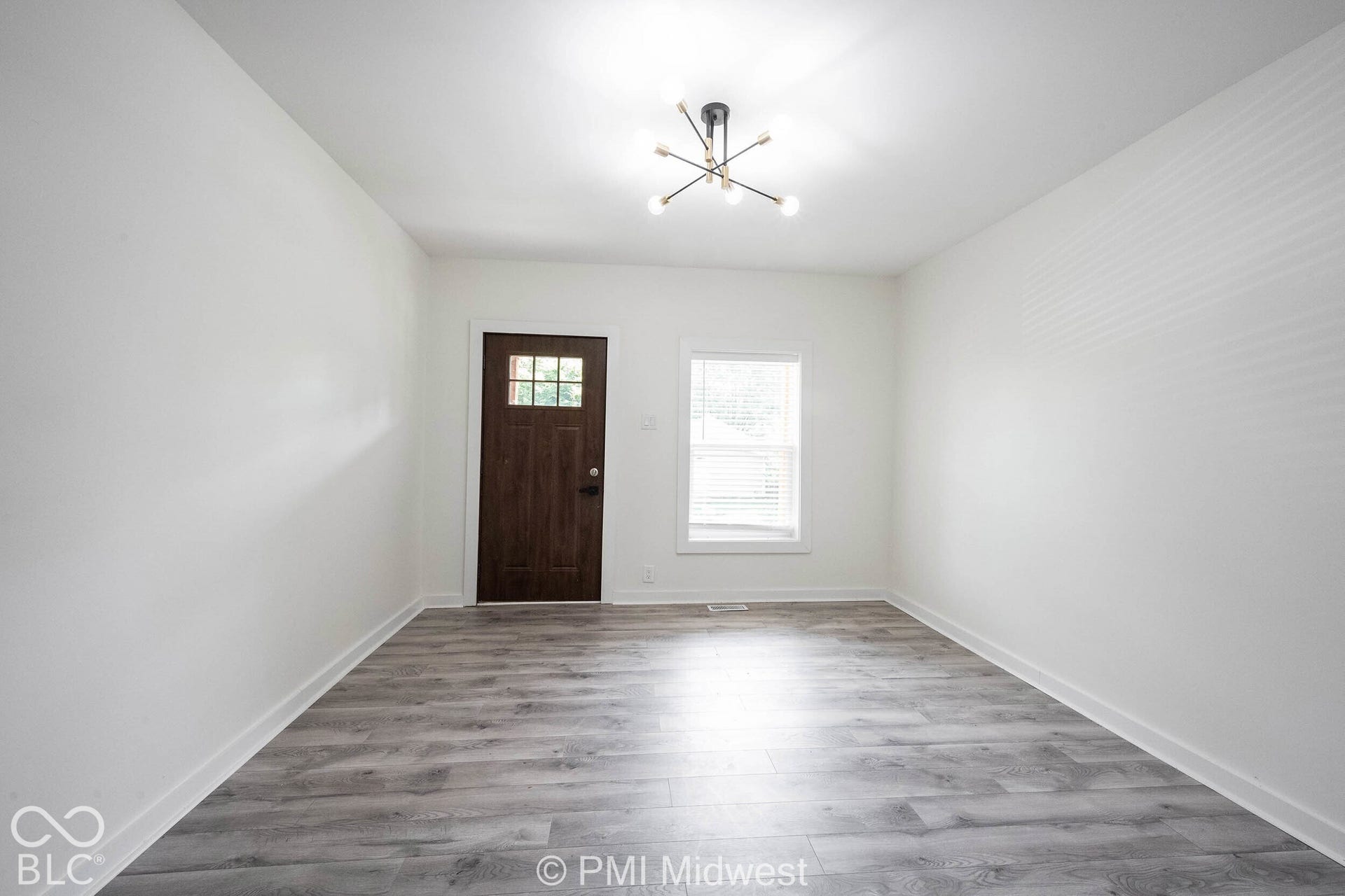 Wood-finish flooring, white walls, and a modern sputnik-style ceiling fixture