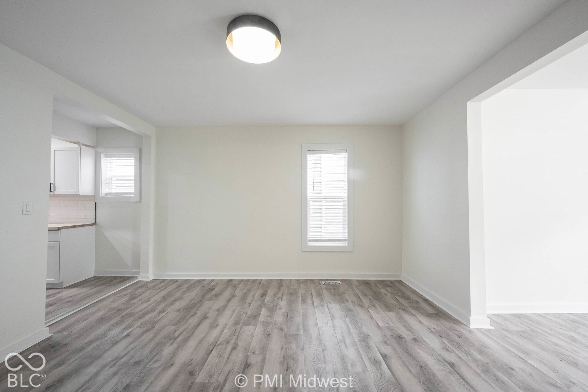 Wood-finish flooring, white walls, and a contemporary ceiling light fixture