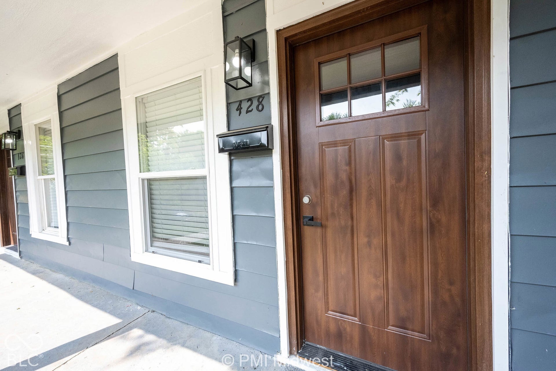 Wood-finish entry door with clear glass lites and dark hardware